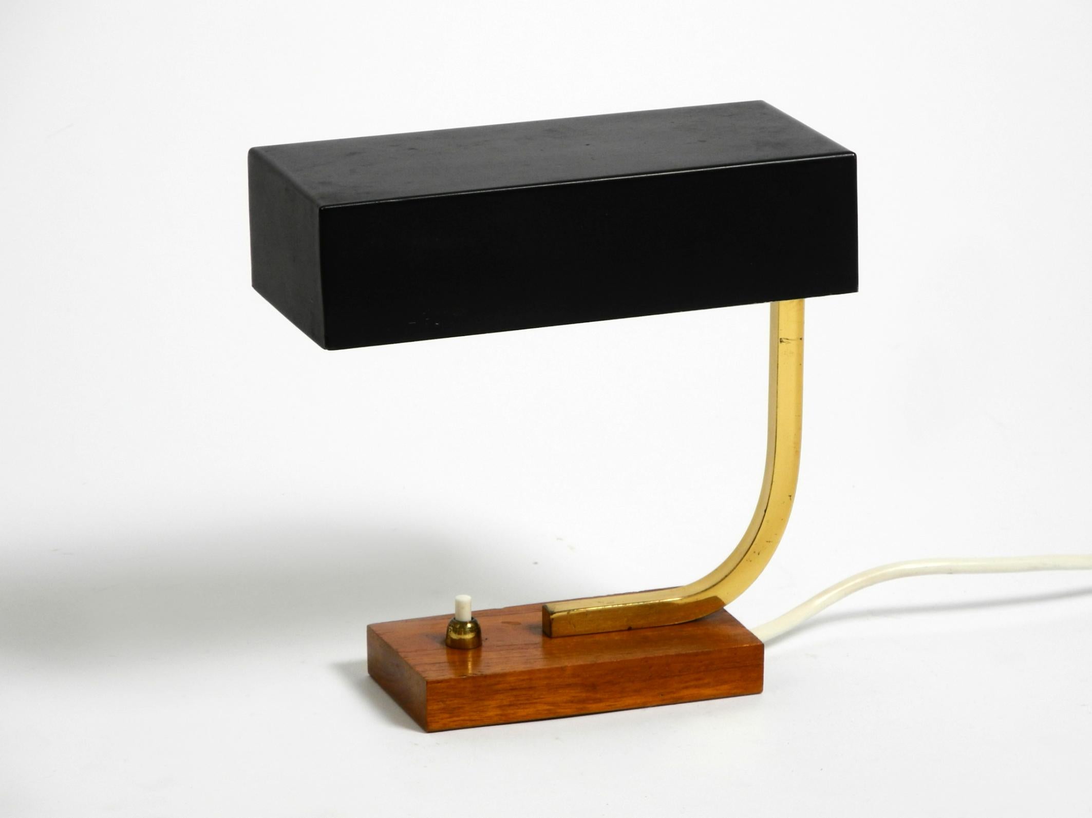 Beautiful Mid Century Modern metal and brass table lamp.
Great minimalist 1950s design. Made in Germany.
Very rare with a rectangular shade, steplessly rotatable.
Very high quality, metal shade, brass neck. Teak base.
Very good vintage condition