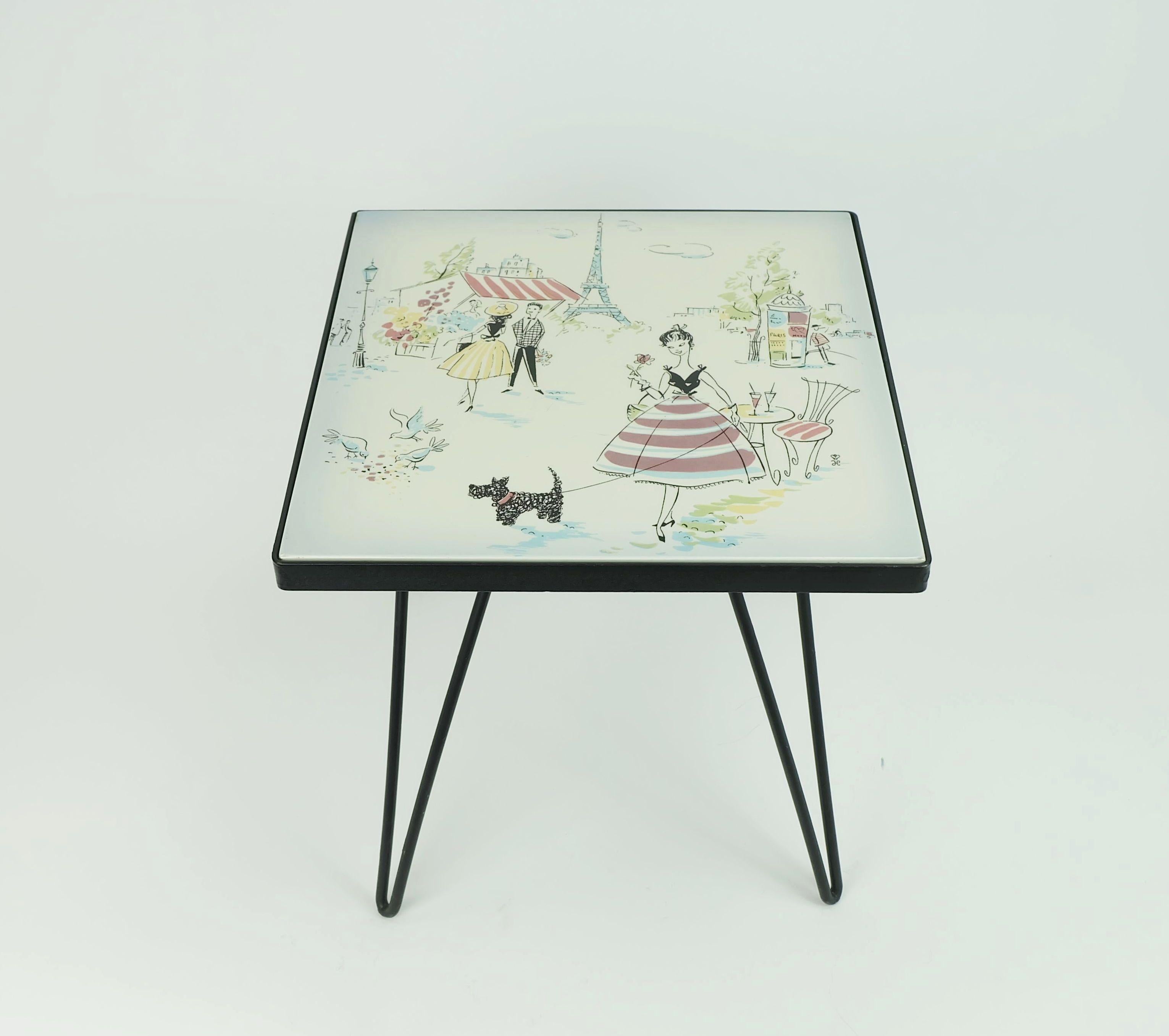 Magnifique petit tabouret végétal des années 1950. Cadre en métal peint en noir avec des pieds en épingle à cheveux, plateau en céramique avec des motifs typiques de Paris.

Dimensions en cm :
Largeur 26 cm, profondeur 26 cm, hauteur 25,5