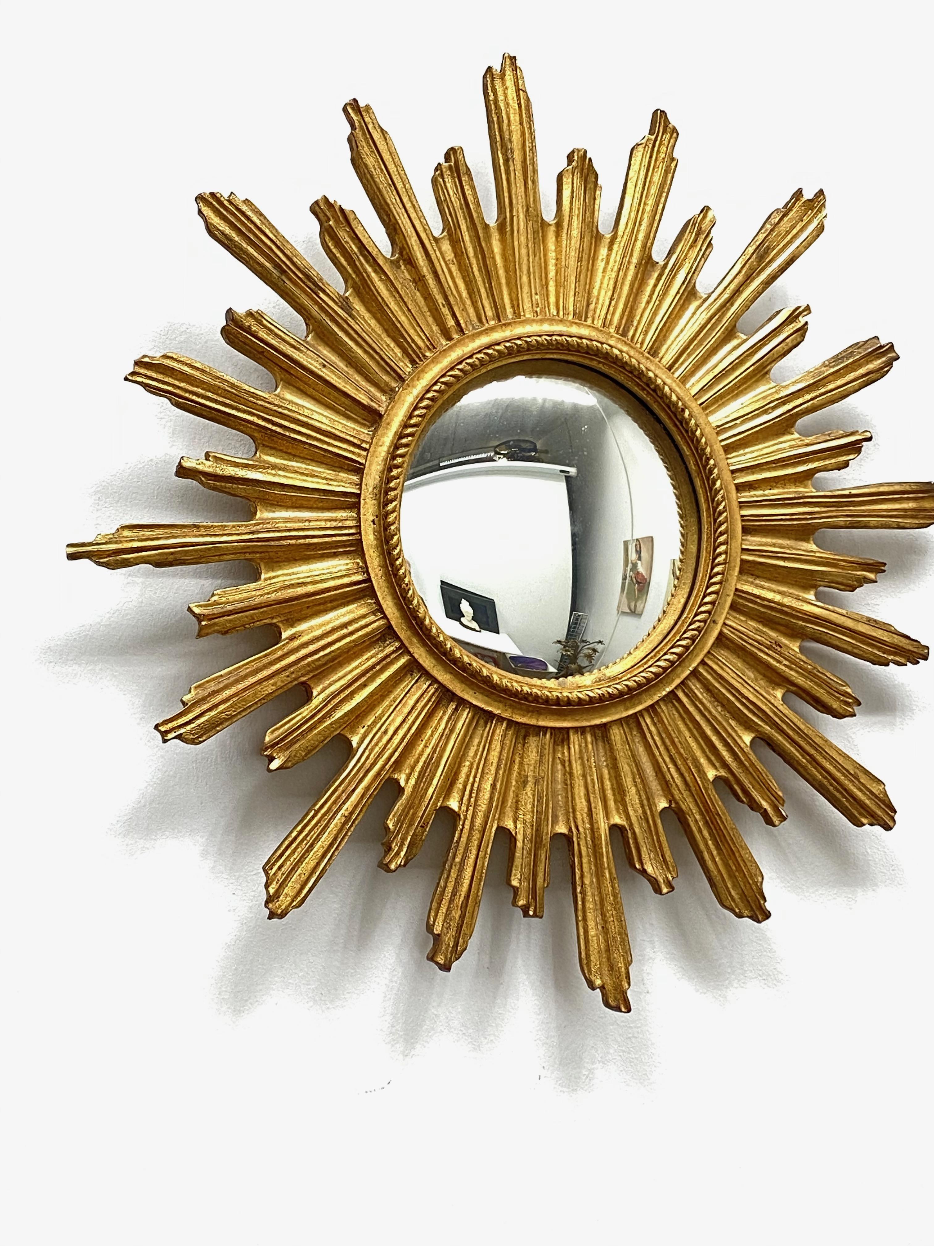 A petite starburst sunburst mirror. Made of gilded resin and wood. It measures approximate 21 1/2