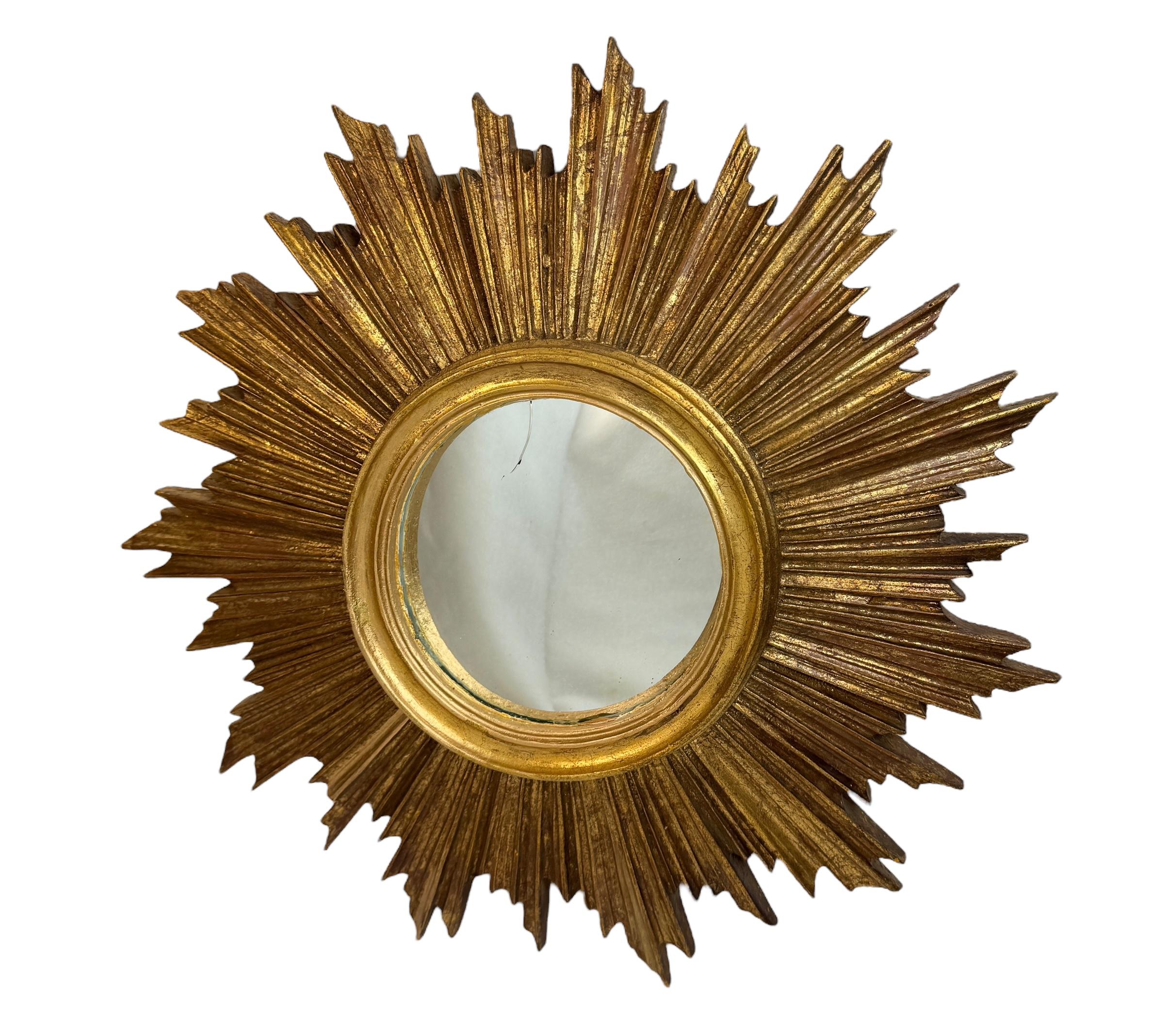 A petite starburst sunburst mirror. Made of gilded resin. It measures approximate 15.75