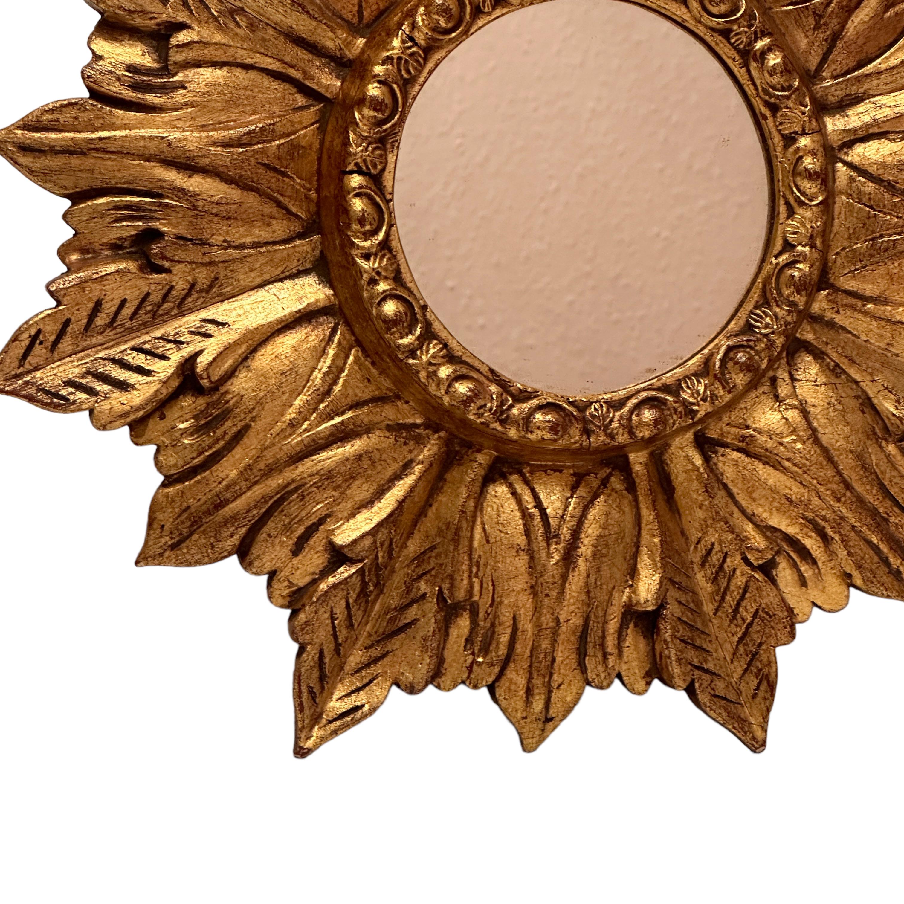 A beautiful starburst sunburst mirror. Made of gilded wood, with a amber color or smoked mirror. It measures approximate 13.63