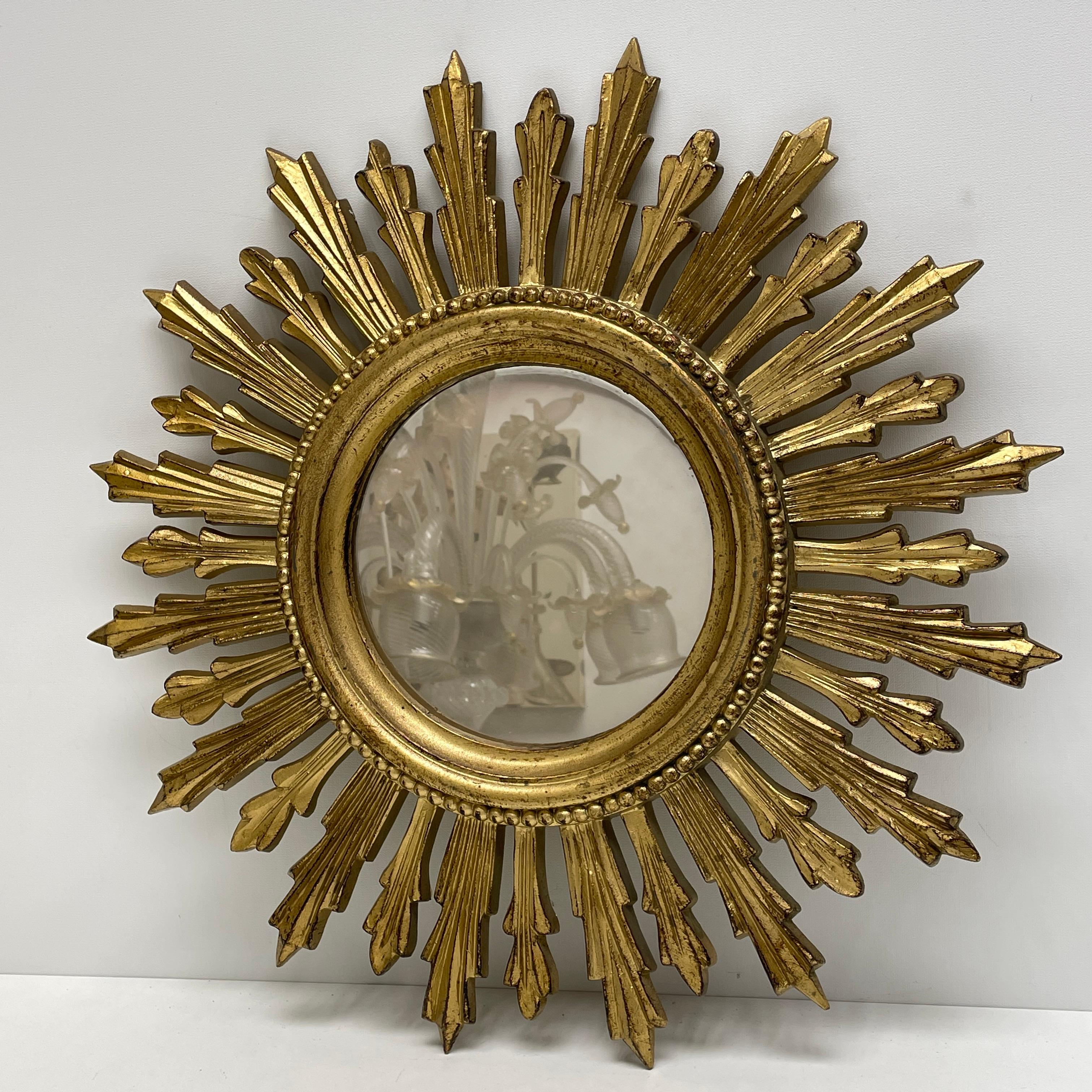 A beautiful starburst sunburst mirror. Made of gilded plastic. It measures approximate 19 5/8