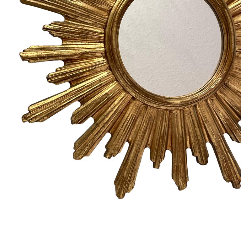 A beautiful starburst sunburst mirror. Made of gilded resin and wood. It measures approximate 20 3/8