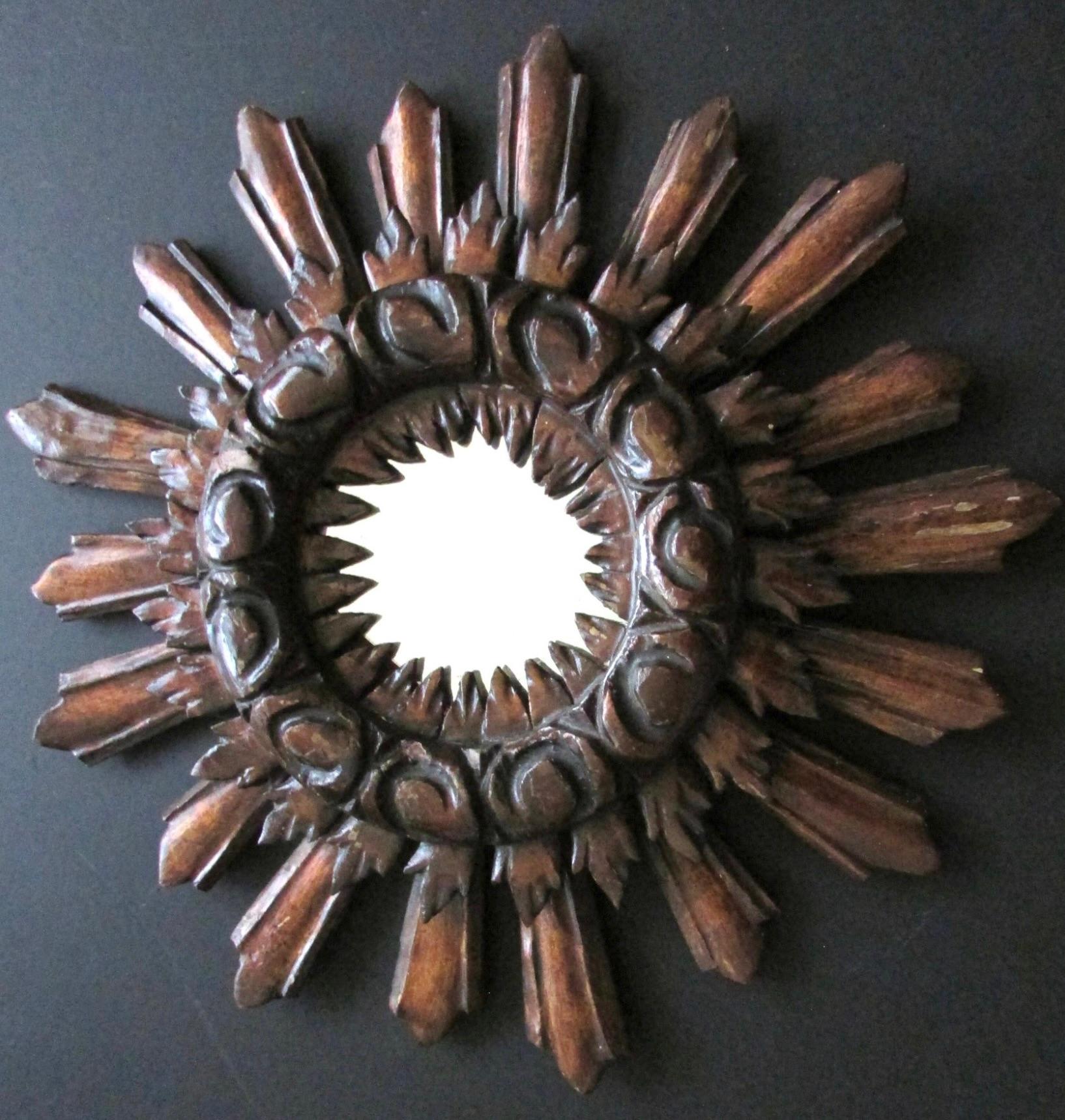 A beautiful starburst sunburst mirror. Made of wood. It measures approximate 17.25