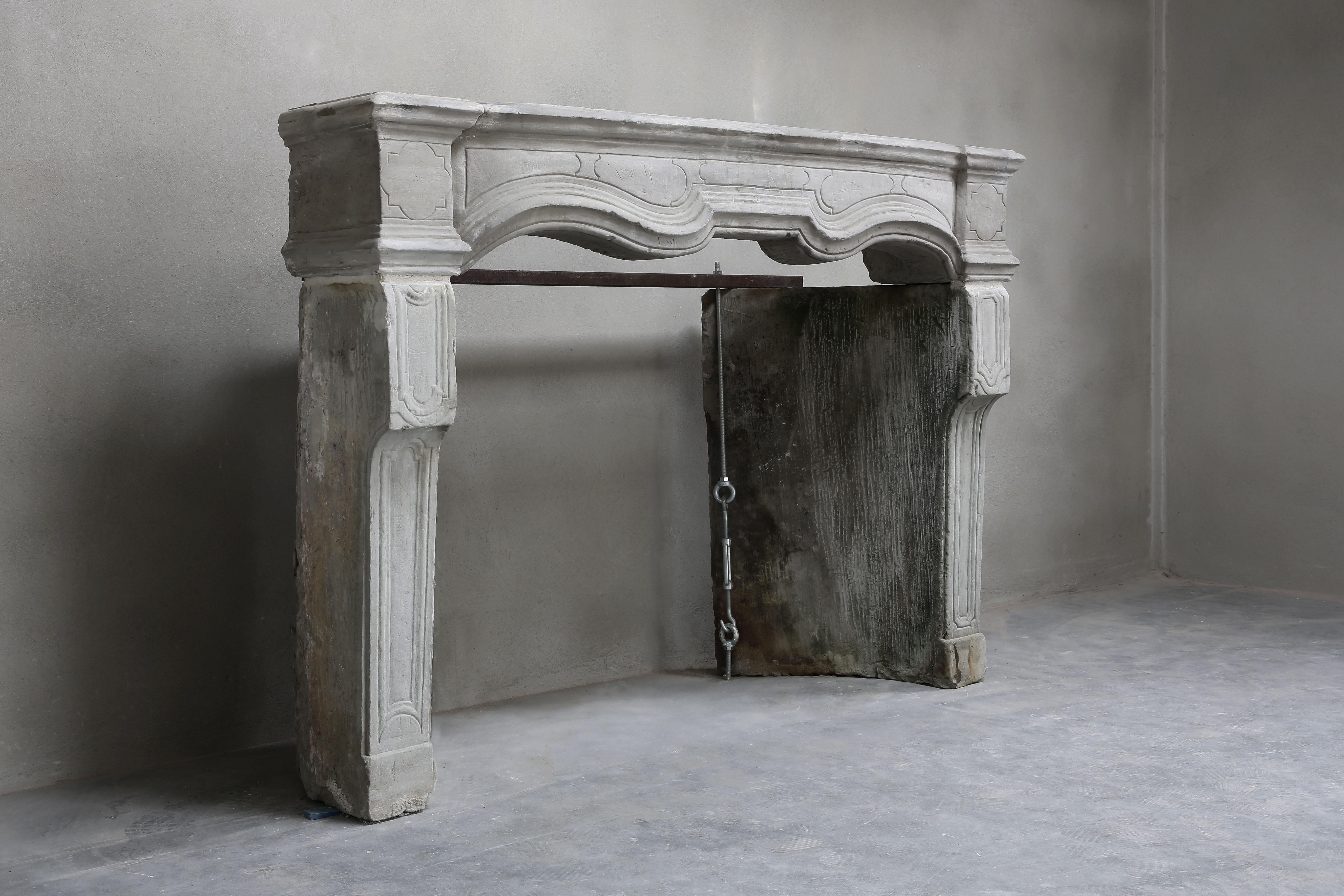 Beautiful stately and carved French limestone chimney from the 18th century in the style of Louis XIV. The front section has beautiful lines. These lines have also been applied in the legs again. This fireplace has a nice molding and shape and can