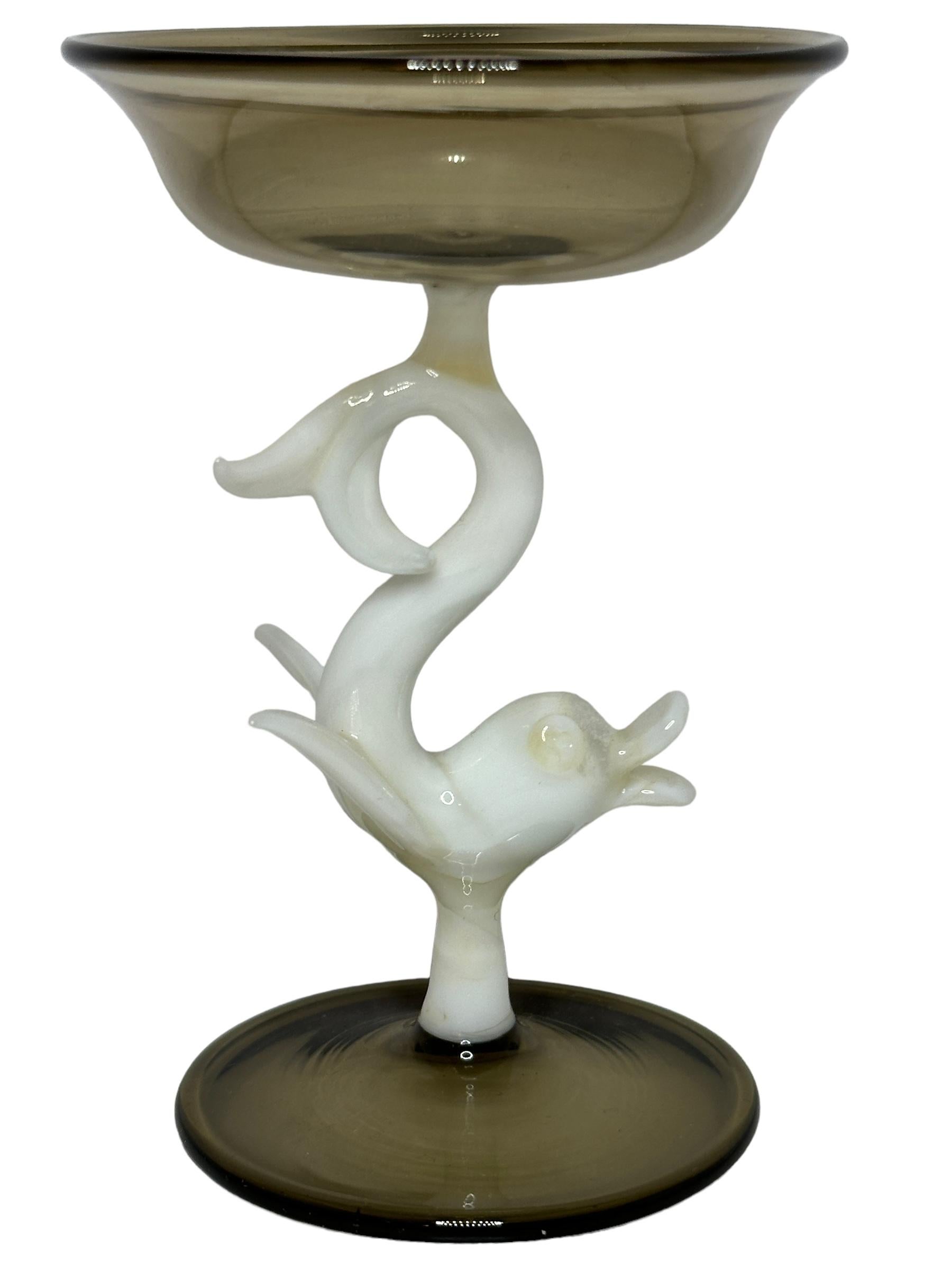 This is a beautiful single vintage stemmed liqueur glass from Austria. It features a dolphin fish shaft and is Bimini art style. The glass has a wonderful design, the stem depicts a dolphin fish in white color. The base and the top is a beautiful