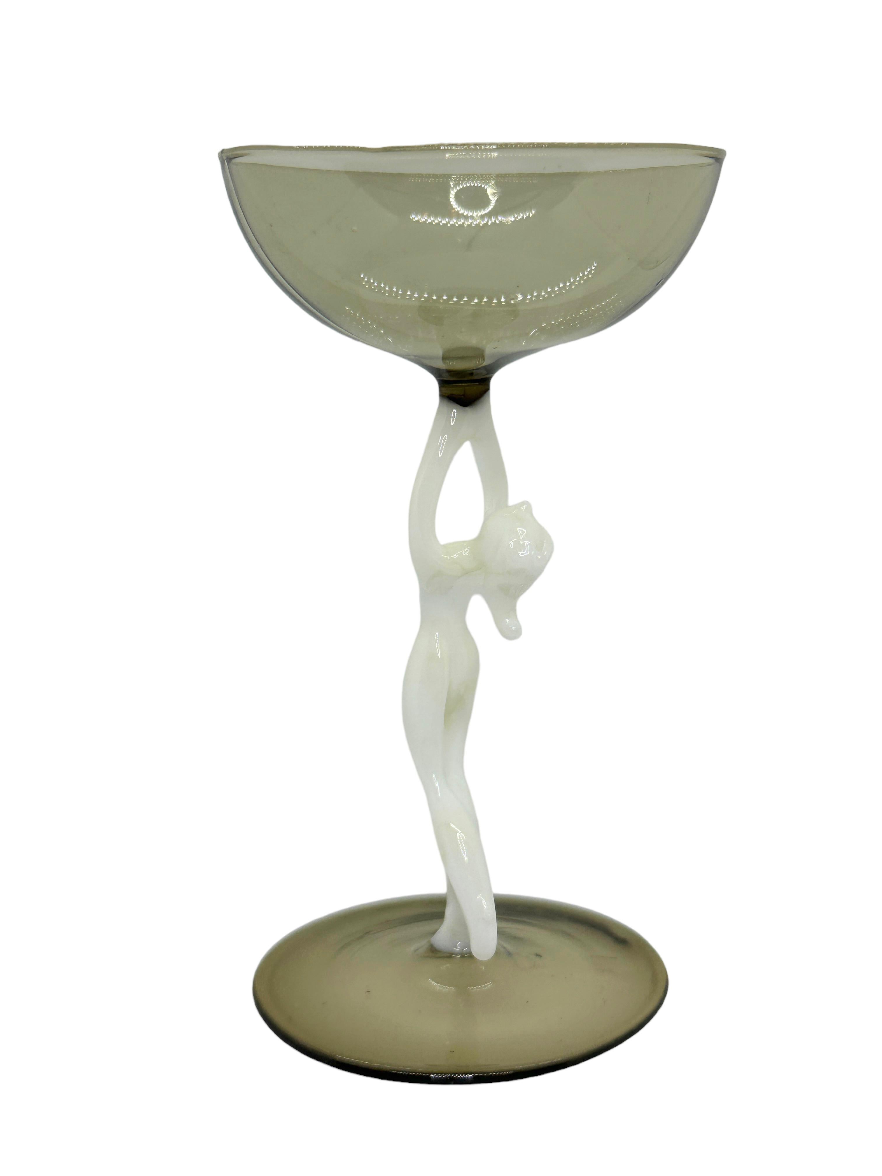 This is a beautiful single vintage stemmed liqueur glass from Austria. It features a bare women's shaft and is Bimini art style. The glass has a wonderful design, the stem depicts a nude lady in white color. The base and the top is a beautiful
