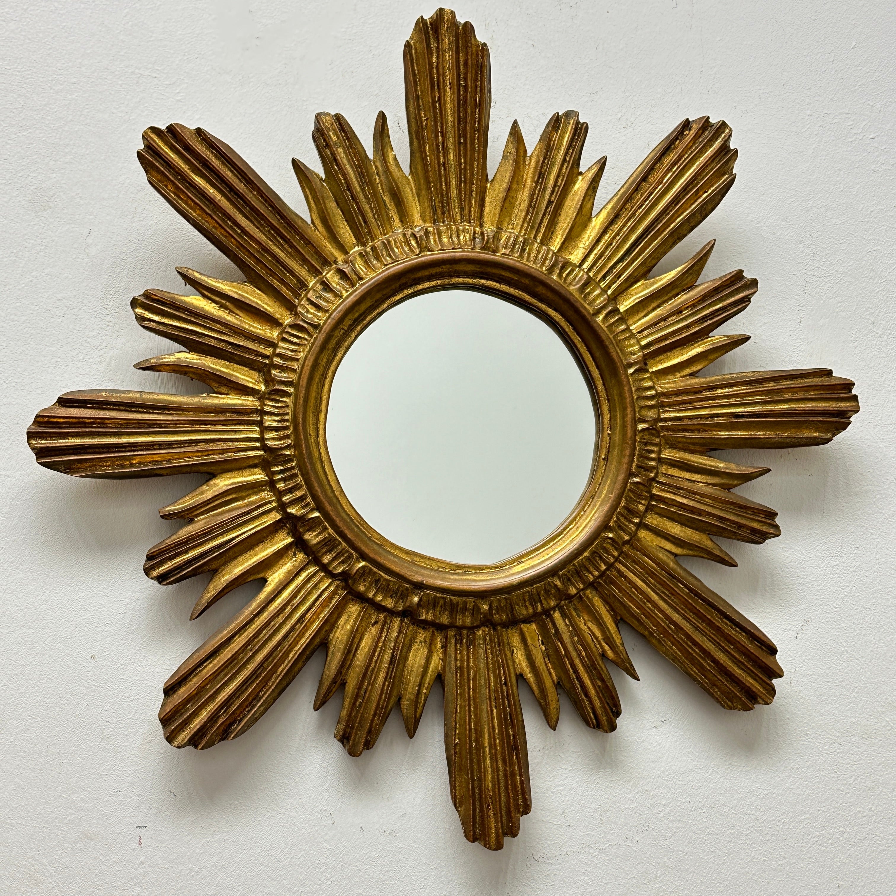 A gorgeous starburst mirror. Made of gilded wood and stucco. No chips, no cracks, no repairs. It measures approximate: 17.5