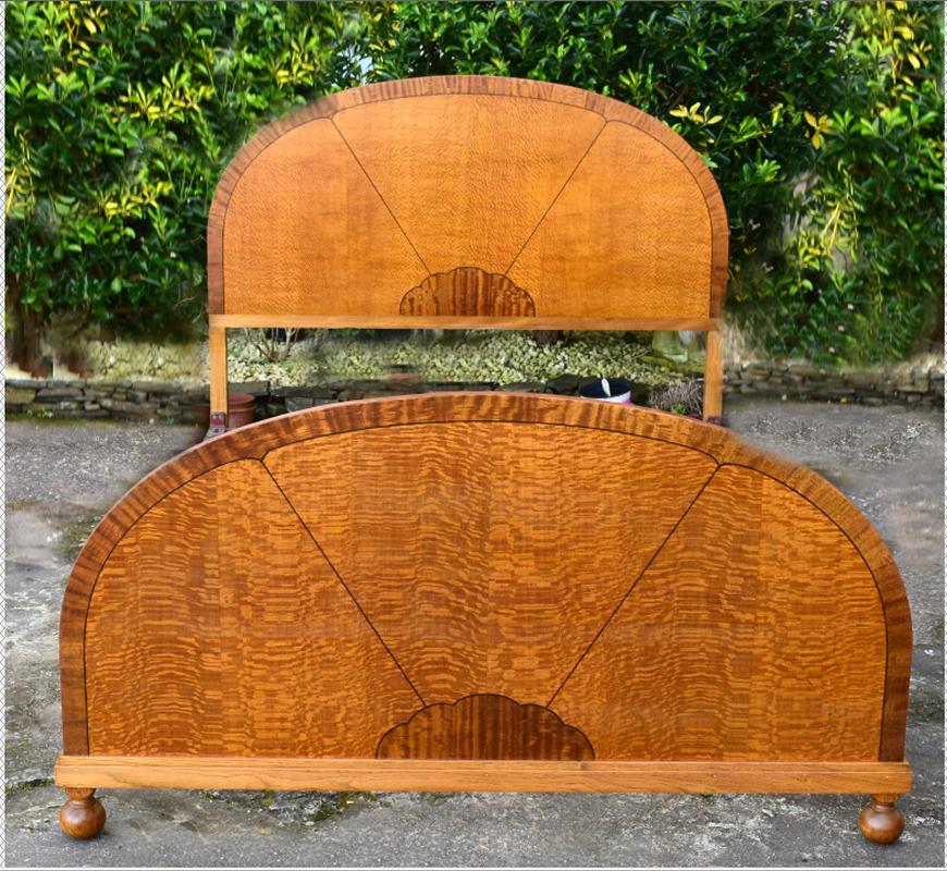 Beautiful Art Deco satinwood veneer double bed dating to the early 20th century with the most wonderful 'sunray' design. This lovely piece has a moon shaped inlaid headboard flanked by metal runners with a similar moon shaped foot board all raised