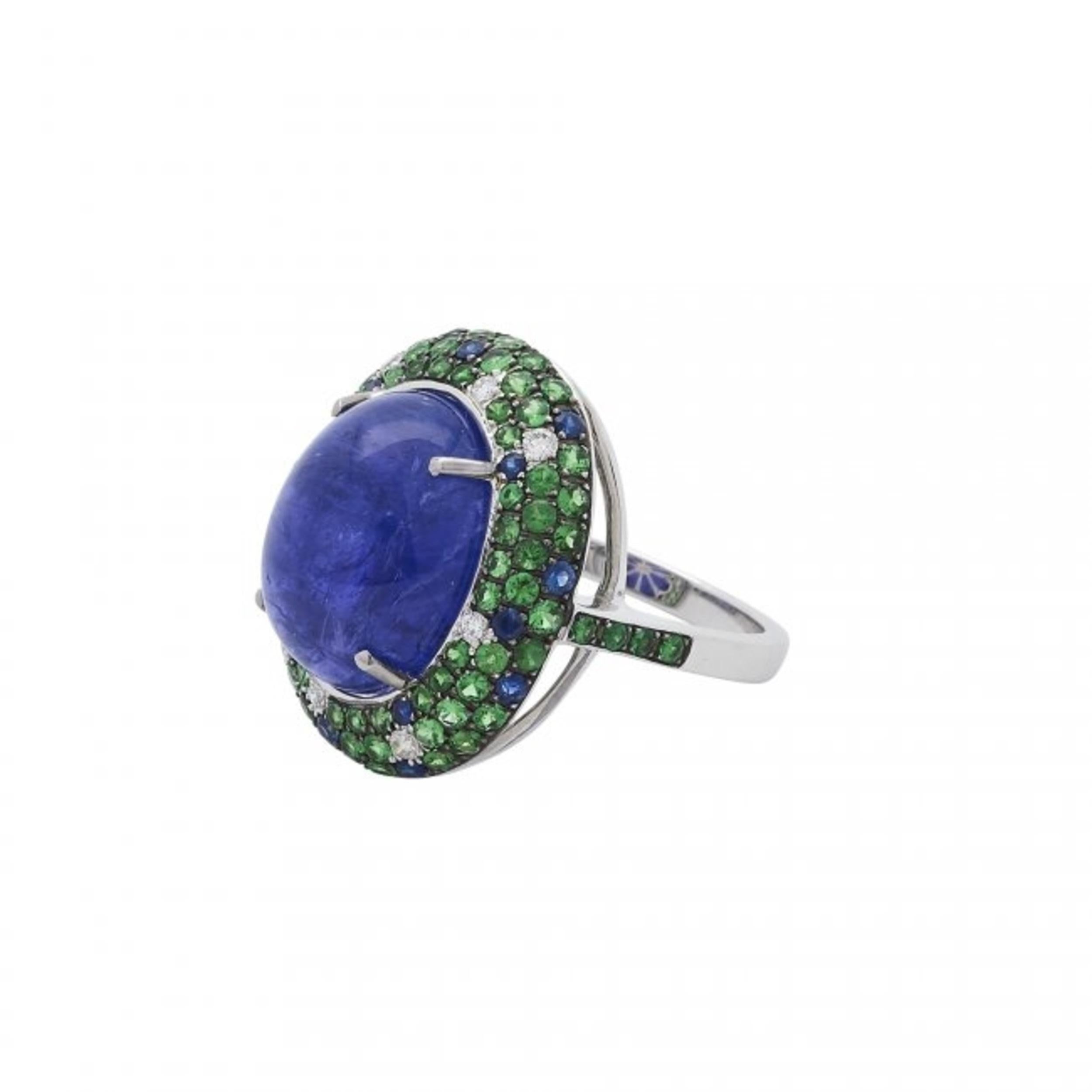 Beautiful Tanzanite and diamond ring centered by a cabochon tanzanite weighing approximately 12.01 carats, within a pavé-set frame of round diamonds, mounted in 18 kt white gold 
8.29 grams (gross), size 6 1/2