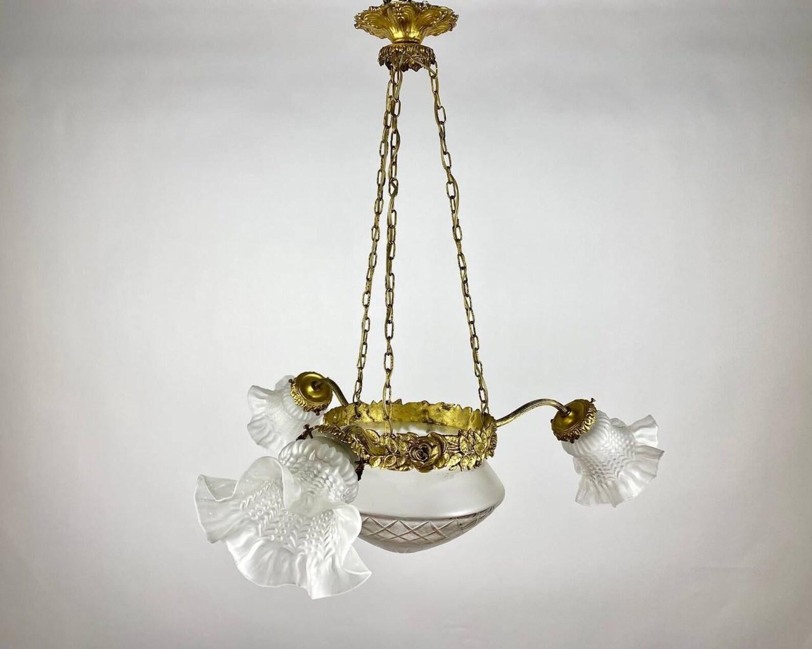 Beautiful vintage three horn chandelier It is an amazing combination of warranty from the manufacturer and the design of the lighting fixture.

 Forged brass frame of gold color and flower shaped glass lampshades perfectly complement the interior of