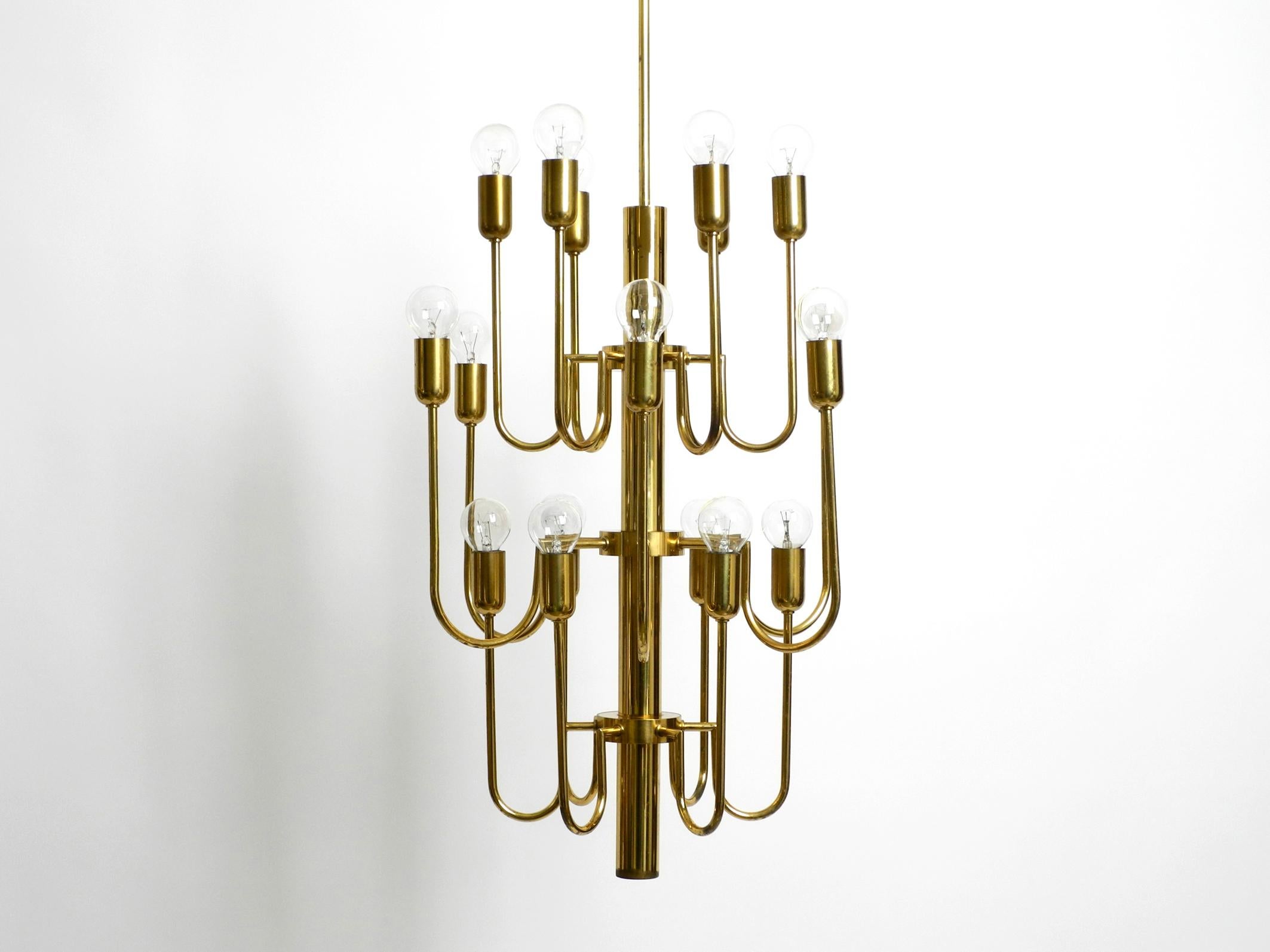 Beautiful midcentury brass chandelier with a long brass rod. The chandelier has 18 arms, each with one E14 socket up to 40W.
Enough light even for large rooms.
Great extraordinary design from the 1960s.
Frame, rod and canopy are made entirely of