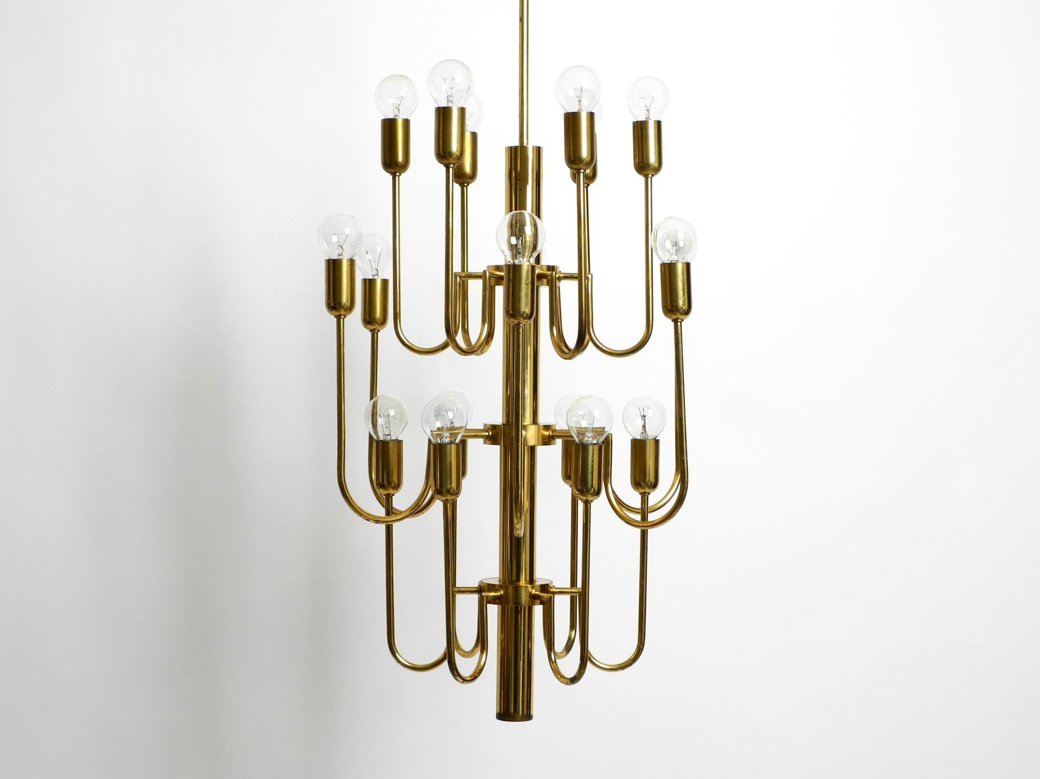 Space Age Beautiful three staged 18 arm Mid Century brass chandelier with a long brass rod For Sale