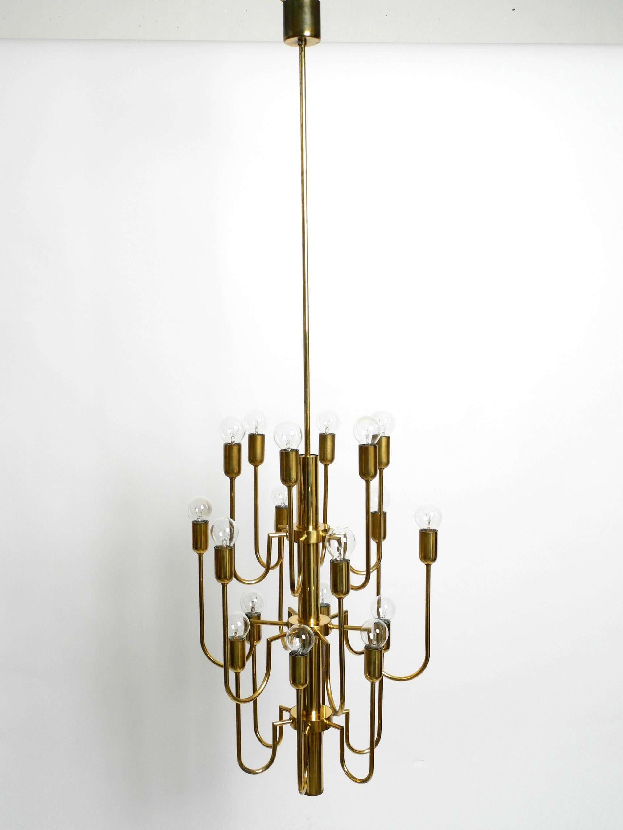 German Beautiful three staged 18 arm Mid Century brass chandelier with a long brass rod For Sale