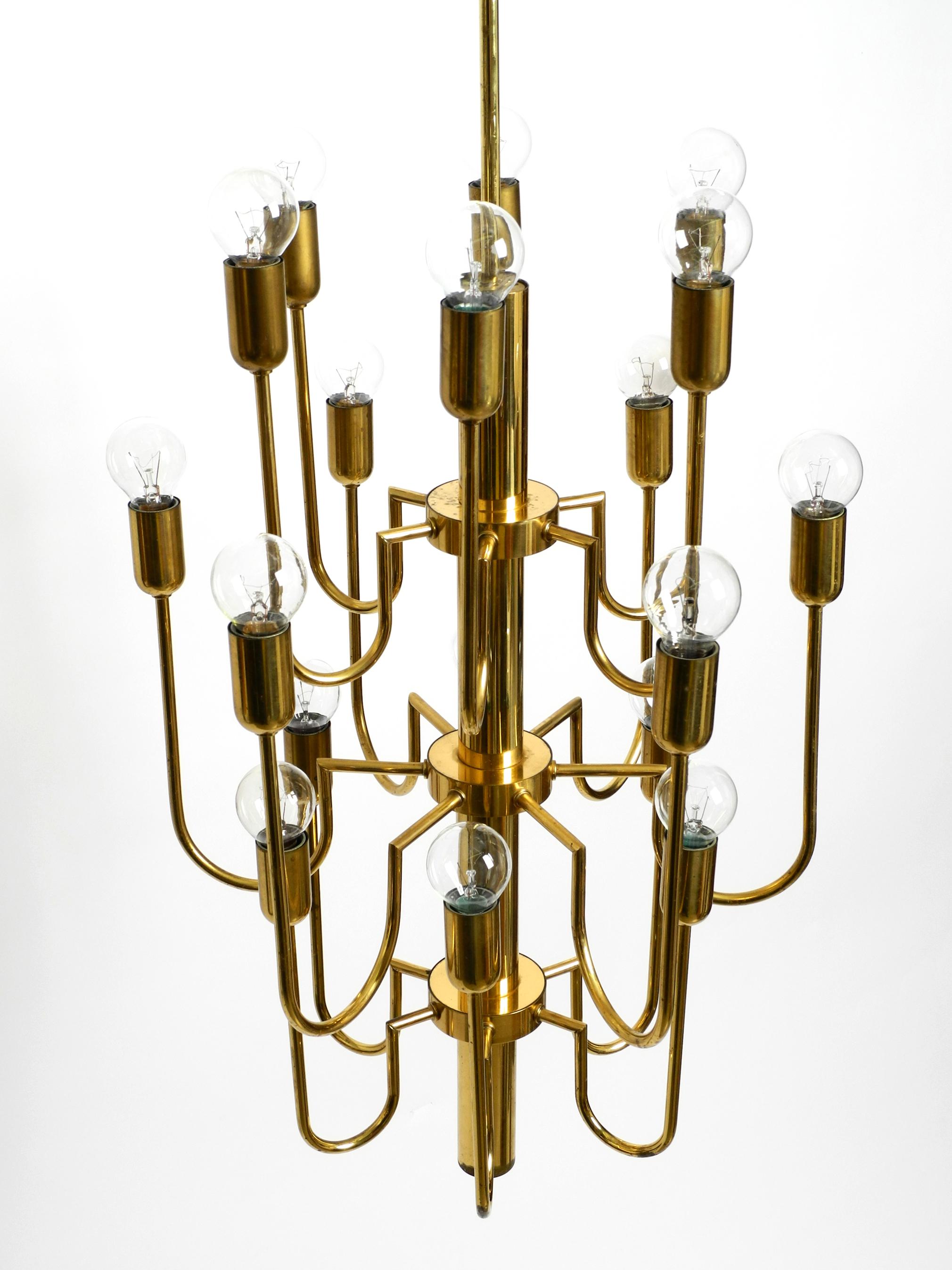 Beautiful three staged 18 arm Mid Century brass chandelier with a long brass rod In Good Condition For Sale In München, DE