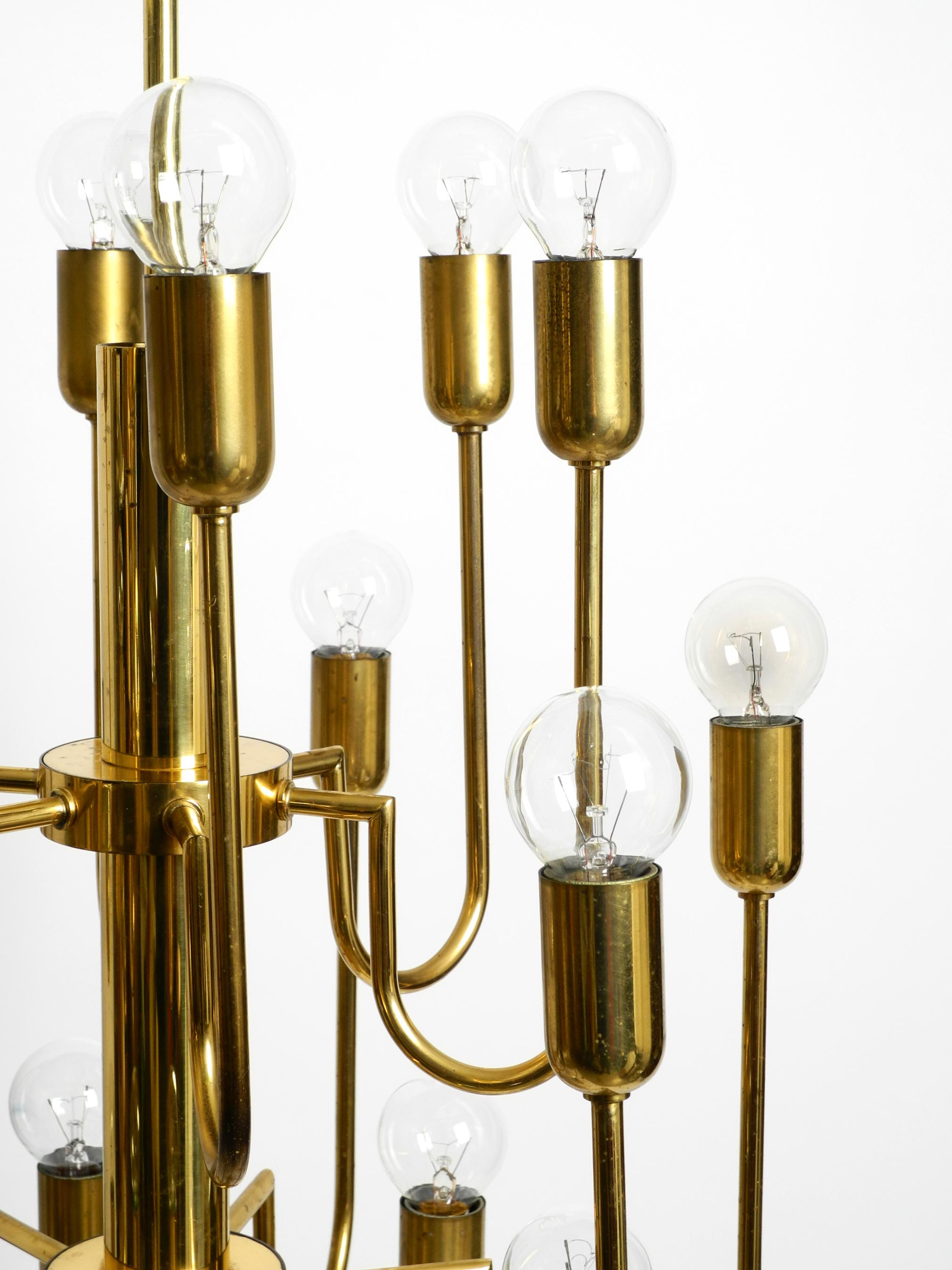 Brass Beautiful three staged 18 arm Mid Century brass chandelier with a long brass rod For Sale