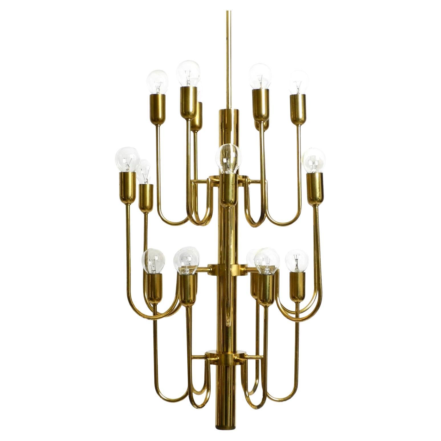 Beautiful three staged 18 arm Mid Century brass chandelier with a long brass rod For Sale