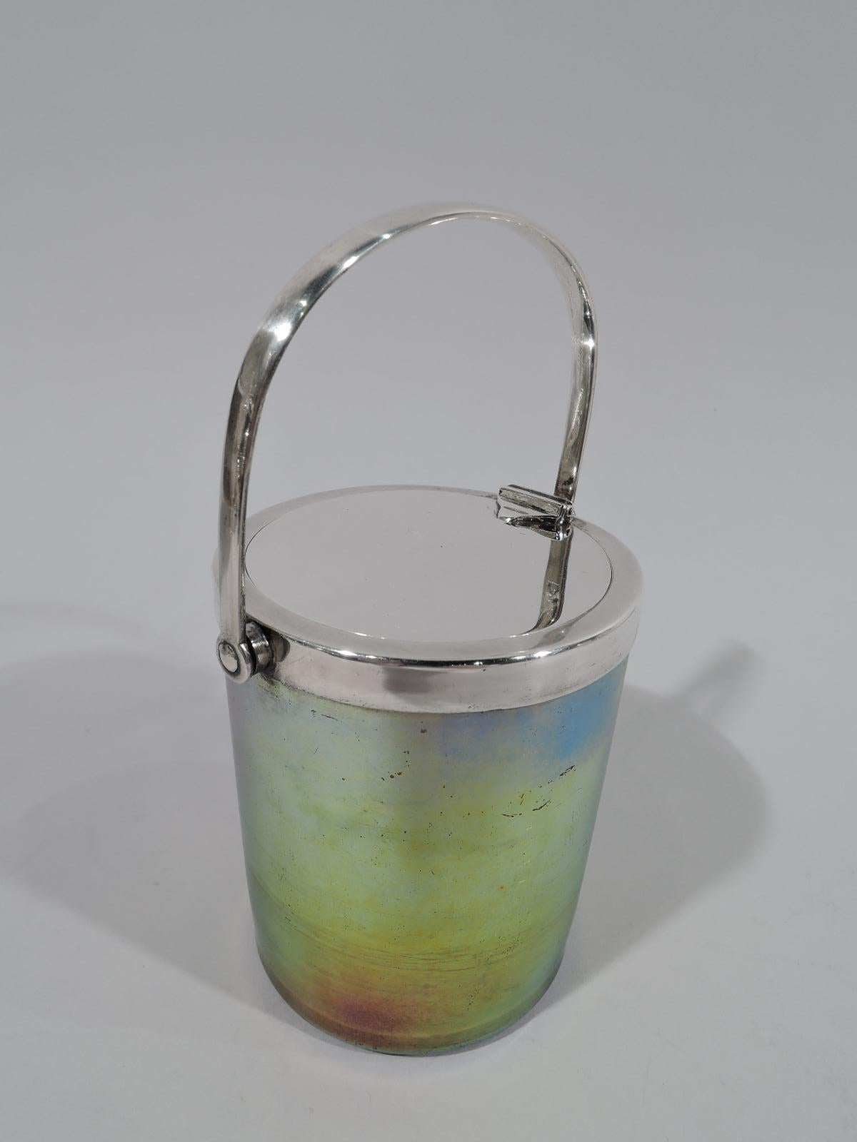 Beautiful Art Nouveau sterling silver and Favrile glass jam pot, circa 1910. Made by Tiffany & Co. in New York. Cylindrical with straight sides. Glass greenish-gold with patches of blue and red. Pontil mark. Silver collar with flat hinged cover that