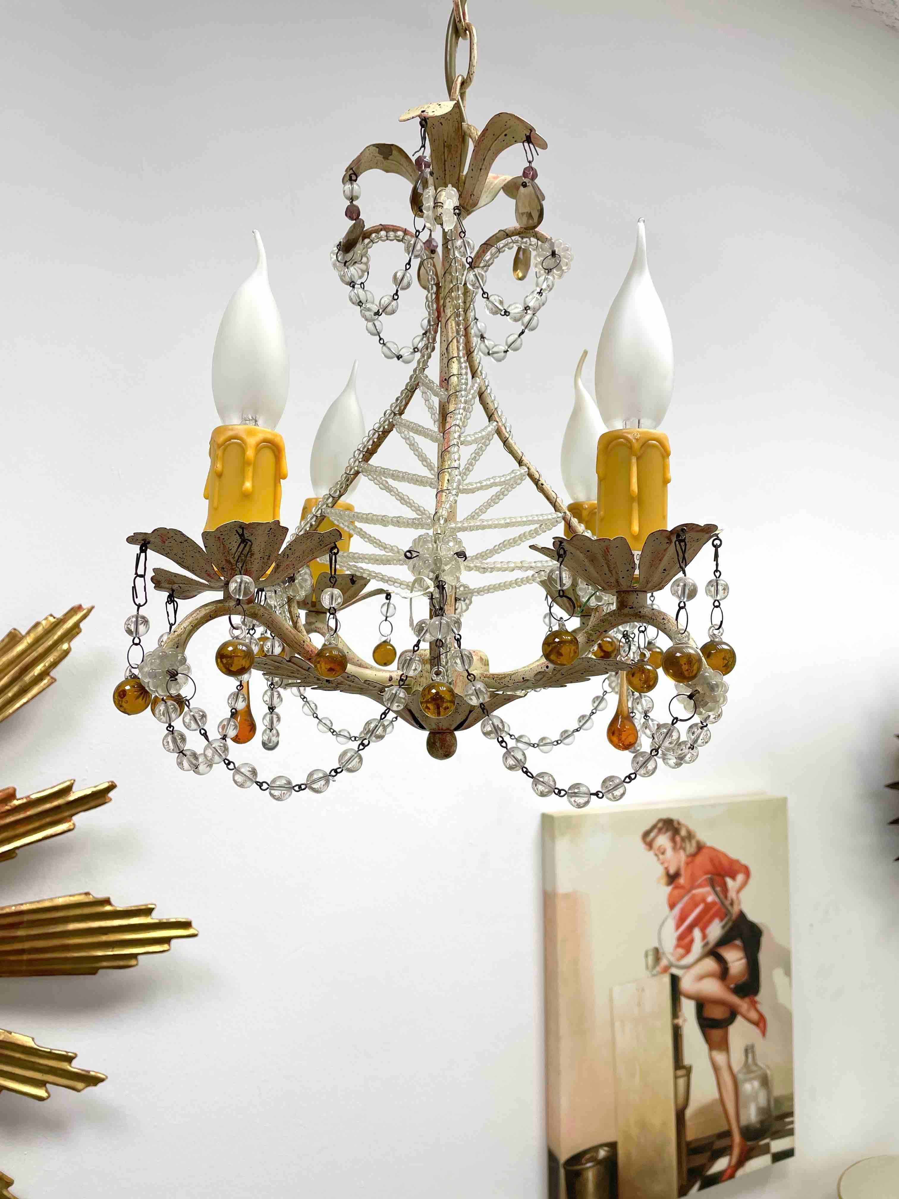 Petite Florentine style four-light chandelier. Functions as is with four E14 / 110 Volt light bulbs. Can take up to 40 Watts each bulb. Beautiful colored metal chandelier with lots fo crystal glass.
It gives the room a beautiful warm light and
