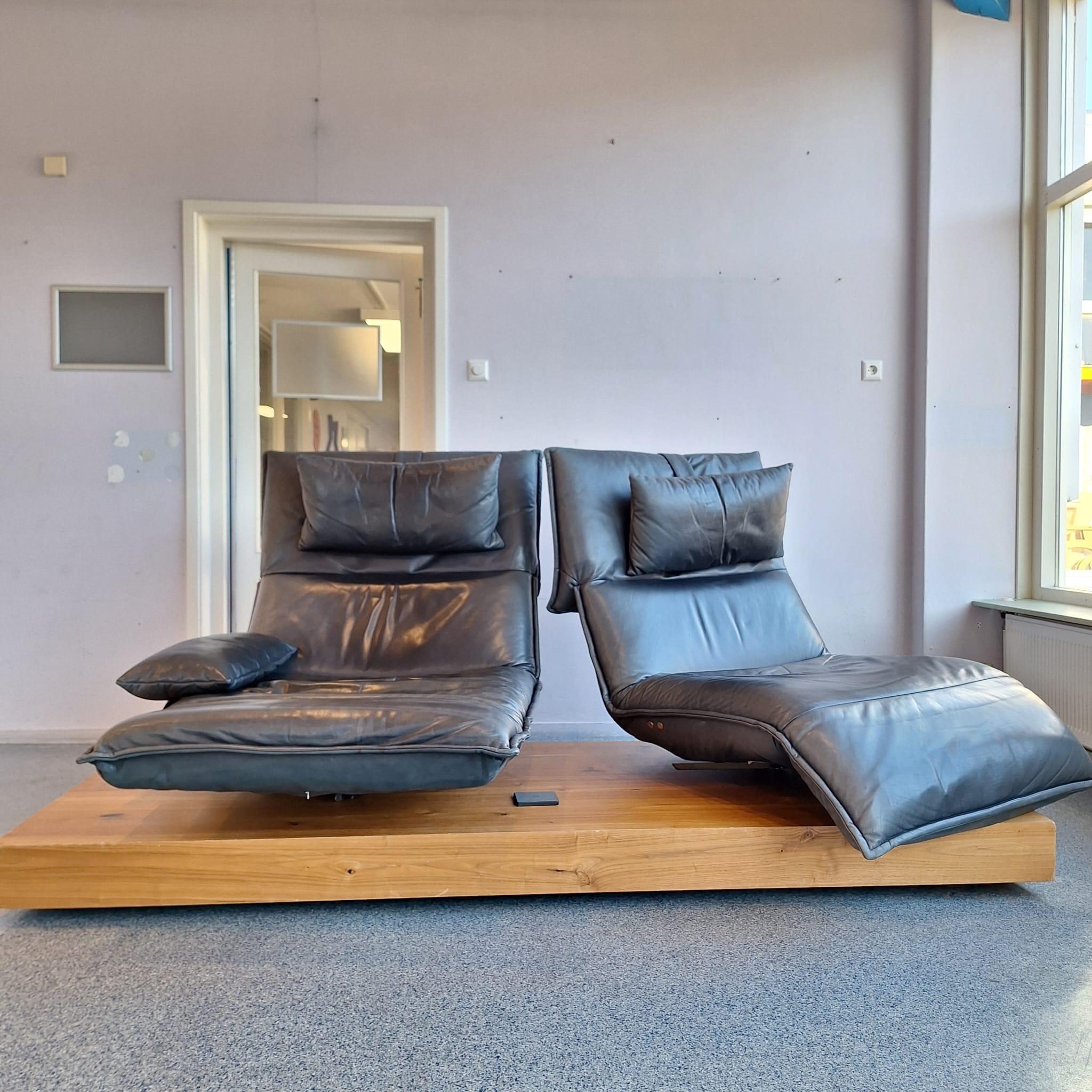 Ein schönes Edit 3 Zweisitzersofa von Koinor. Die Sitze können sich um ihre eigene Achse drehen und die Sitzposition kann dank der stufenlosen Verstellung der Fußstützen und der Rückenlehne per Knopfdruck verändert werden. Die Sitze können auch
