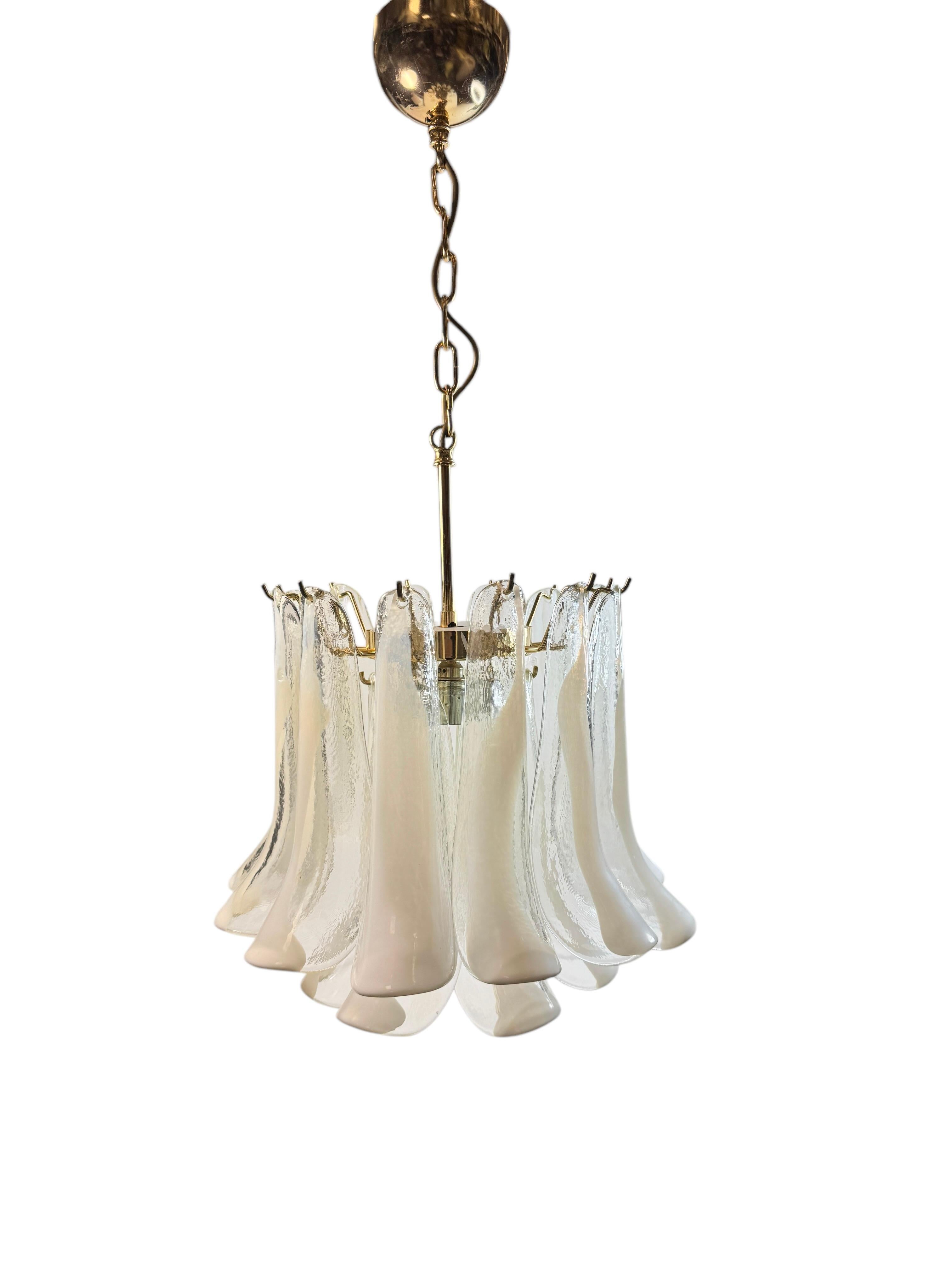 Uno splendido lampadario italiano a quattro luci in vetro di Murano soffiato a mano con struttura in ottone. Elementi di petali in vetro bianco e trasparente. Soffiato a mano nell'isola di Murano, in Italia. La catena con baldacchino e asta è lunga