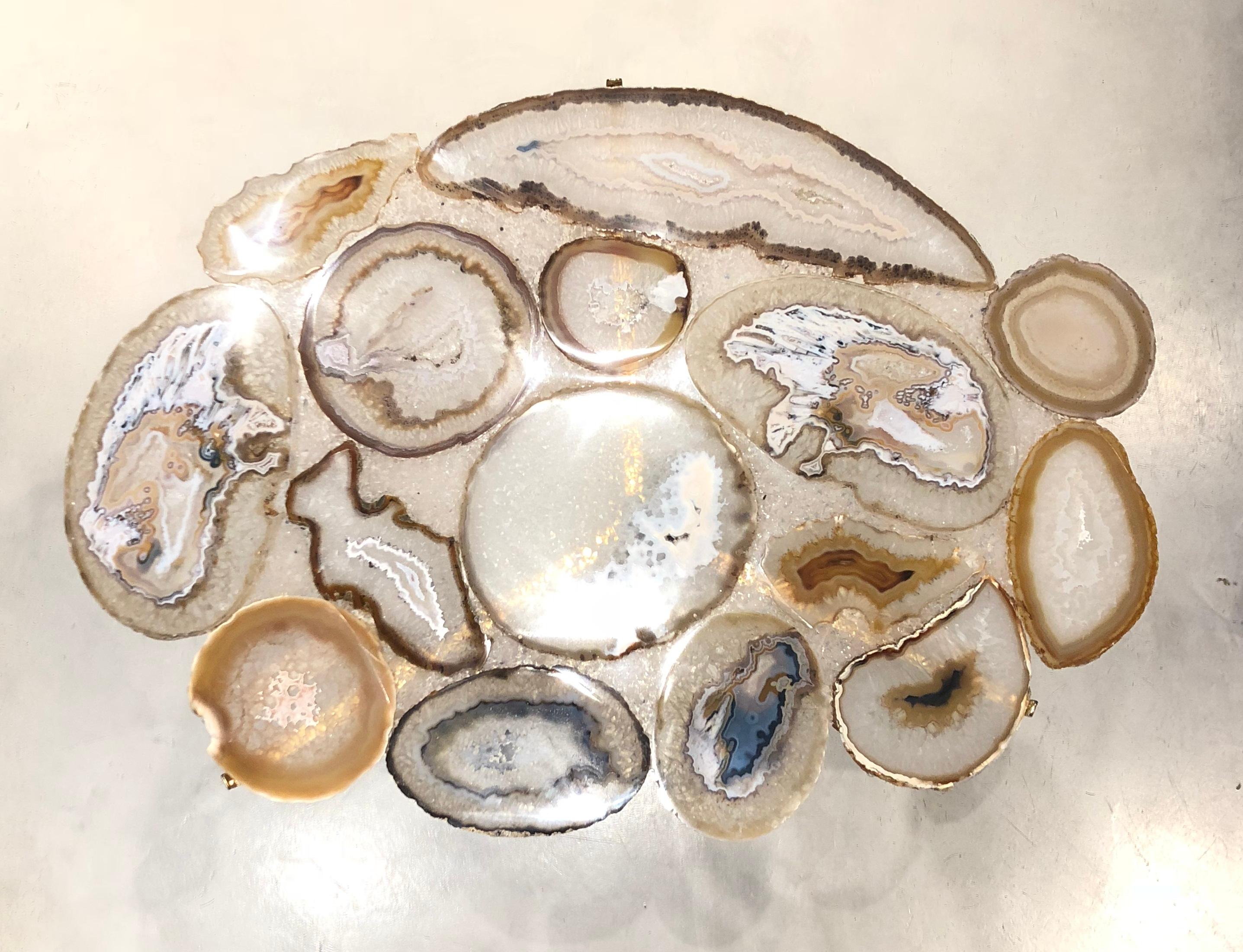 Created with resin and agate blades natural. Base in polished brass.
The natural stone integrates with the different design languages, combining straight and sinuous curves in a sophisticated fluidity.
The different colors of stones range from
