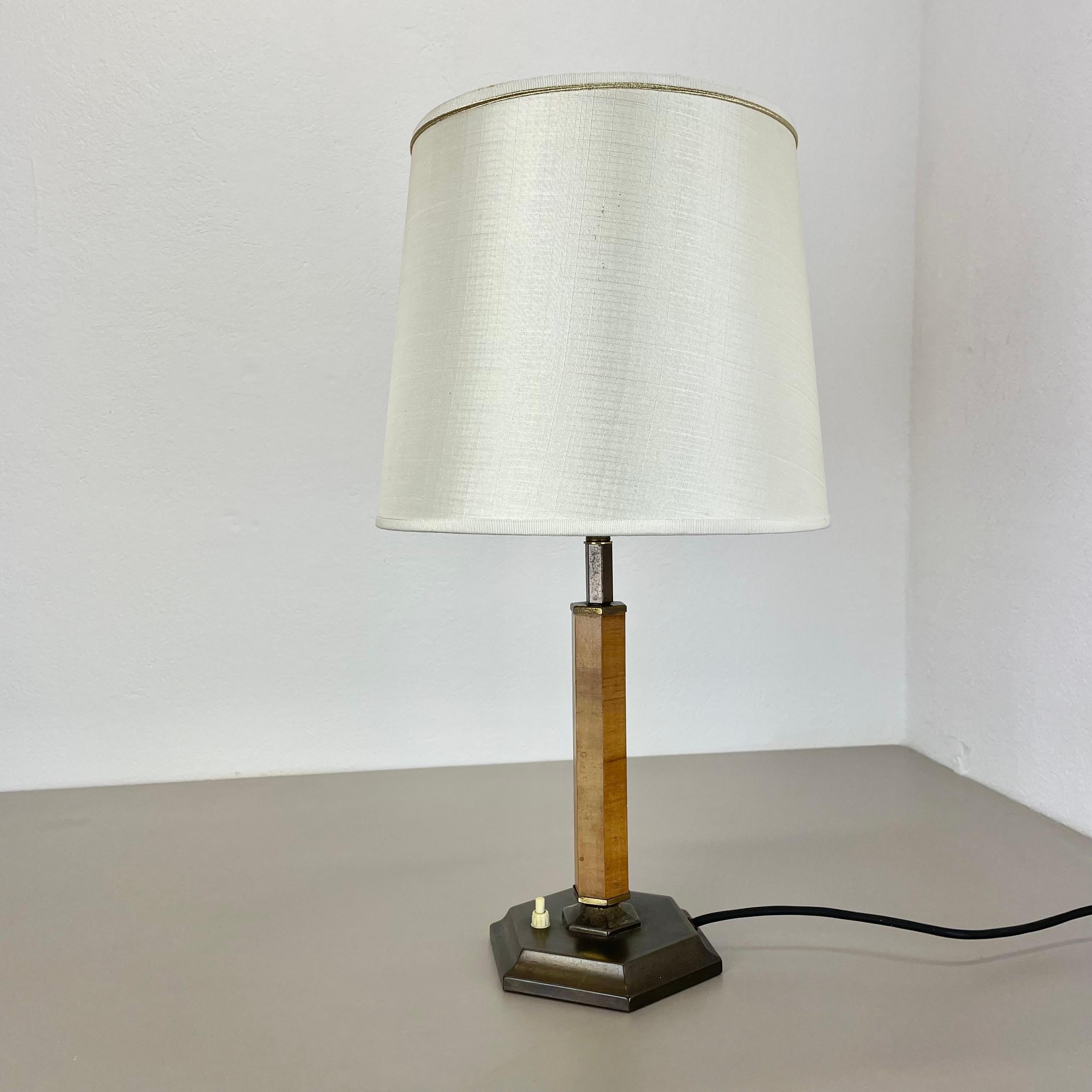 Article:

table light


Origin:

Germany


Age:

1930s


This original vintage table light was designed and produced in the 1930s in Germany. the super rare and minimalist stand element is made of brass combined with a formed wooden stand element.