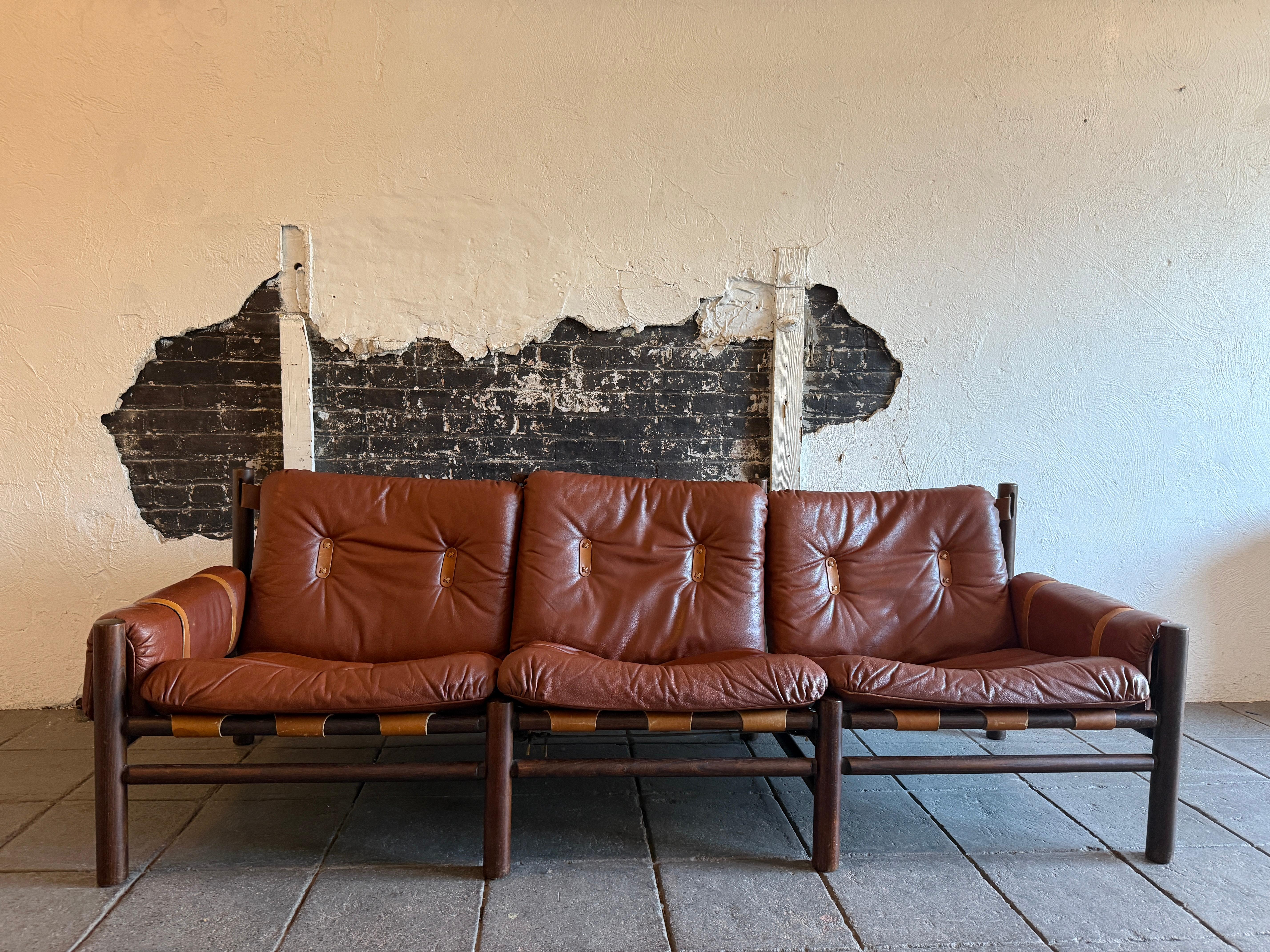 Bellissimo divano a 3 posti in pelle safari con imbragatura bassa del Mid Century Furniture, realizzato da Bruksbo, produttore di mobili norvegese. Un rarissimo divano safari a 3 posti di Brukso / Stranda, Norvegia. Questo divano non è solo un
