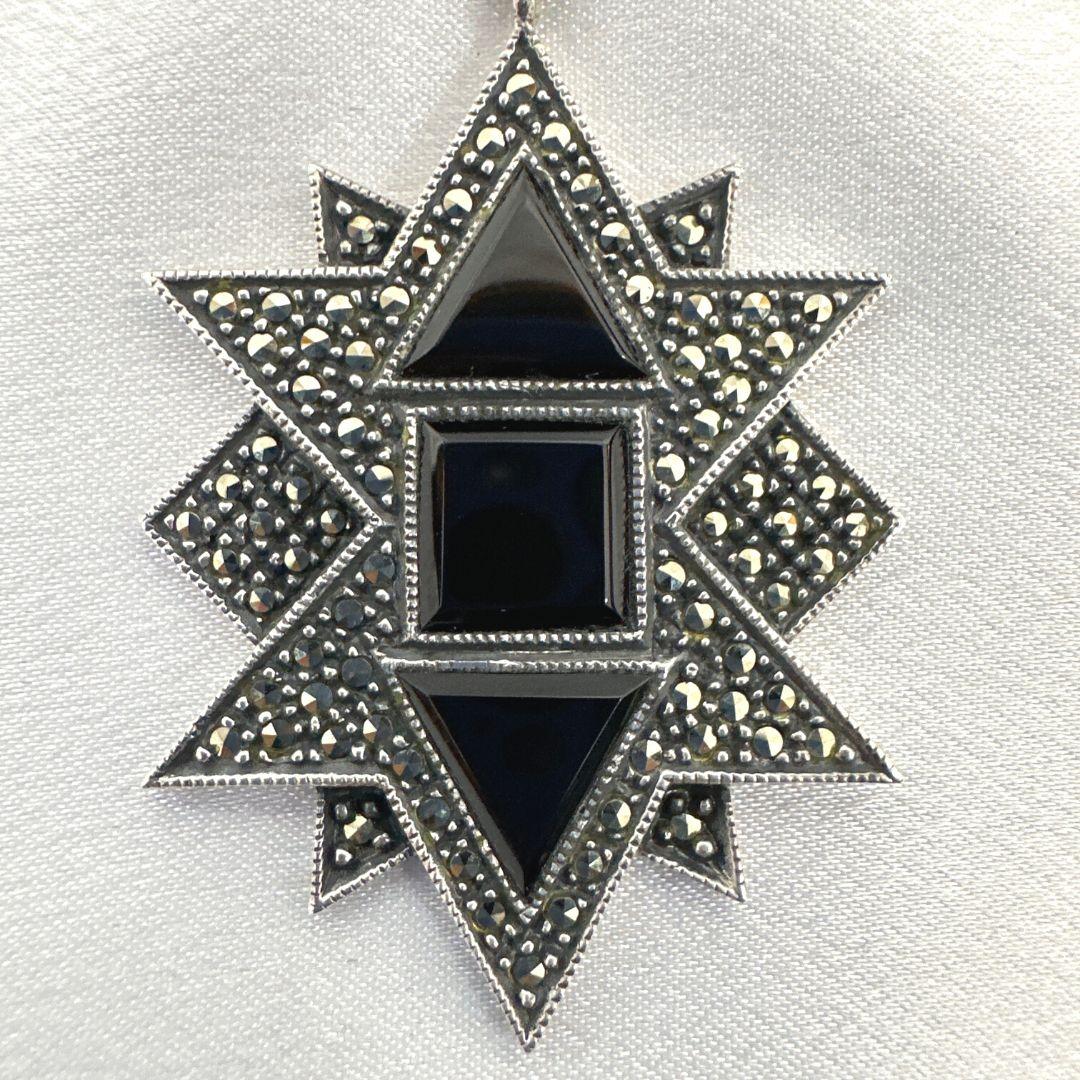 Eleganz trifft auf Individualität in dieser schönen, einzigartigen Brosche aus Sterlingsilber, die mit einem Onyx-Kristalltropfen verziert ist. Mit einer Länge von 3,15 cm und einer Breite von 1,45 cm ist diese Brosche ein zierliches, aber