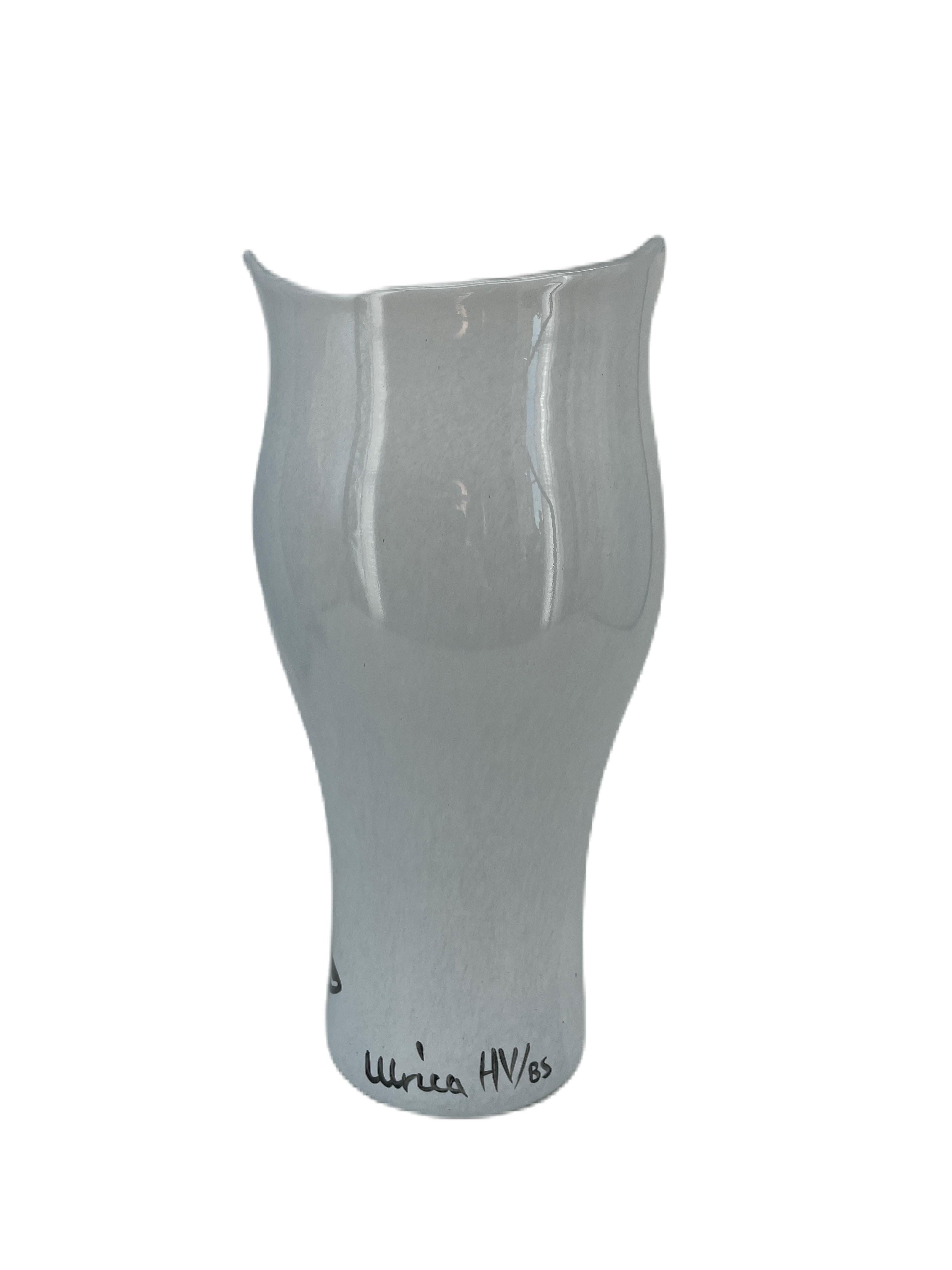 Vase en verre Ulrica Hydman Vallien avec forme de tête, verre blanc et caractéristiques stylistiques. Il est soufflé à la bouche et décoré à la main, ce qui lui donne un aspect unique. Ulrica a conçu ce vase dans les années 2000 dans le cadre de la