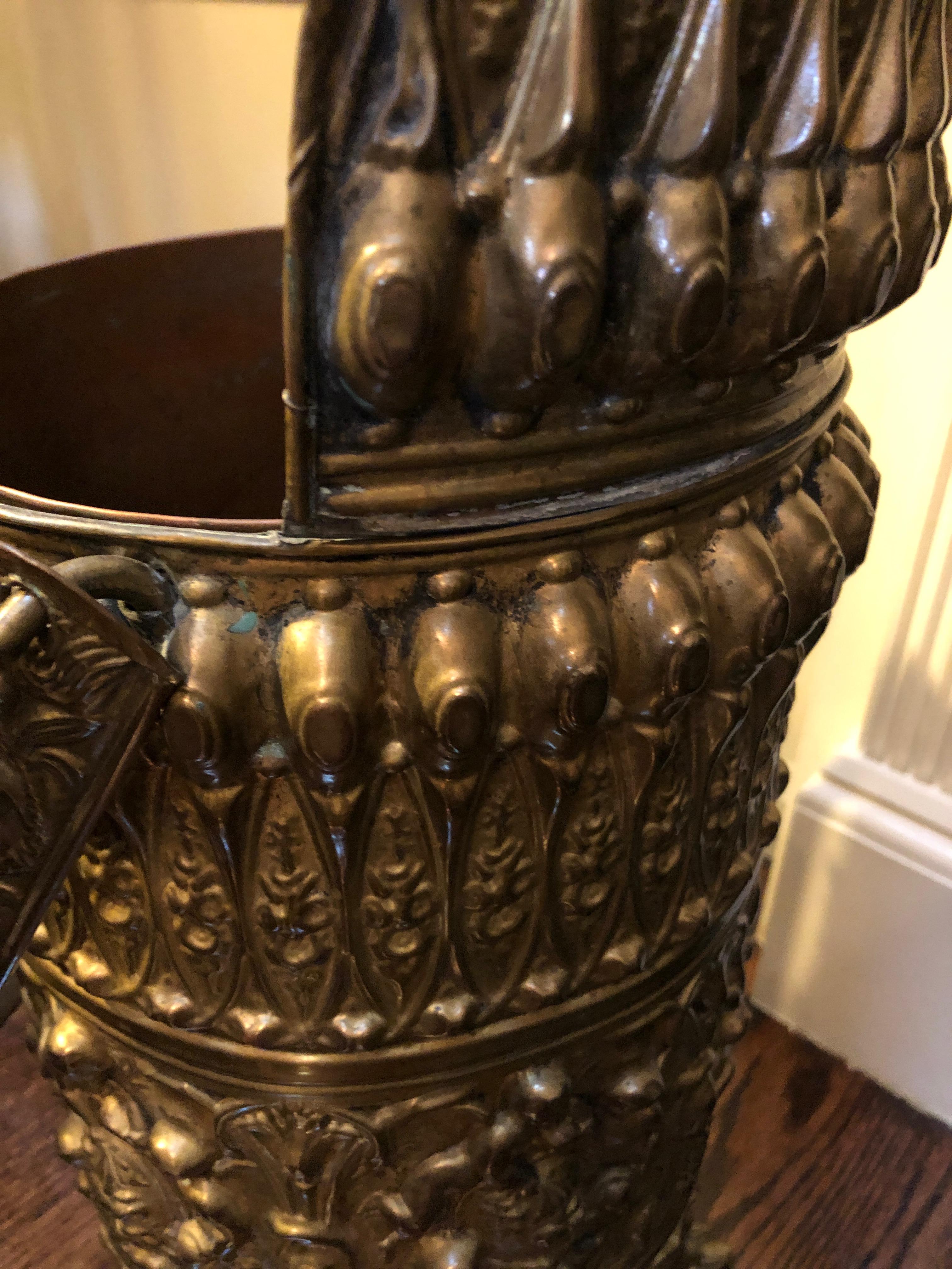Wonderful example of a Victorian brass coal scuttle with a copper lining, rows of repousse’ decoration on the body and a moveable handle. 
The scuttle is raised on cast paw feet.