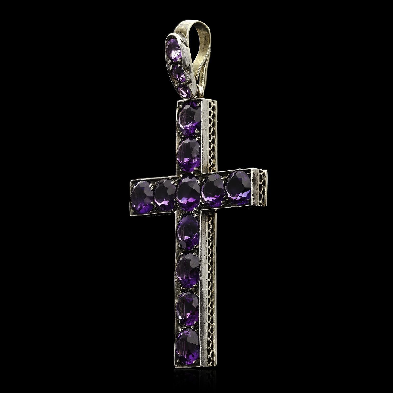 A beautiful Victorian Latin style cross pendant c.1860s set with eleven finely matched round faceted amethysts of deep richly hued purple colour all set in silver backed with yellow gold which has been finely pierced to create a delicate scalloped