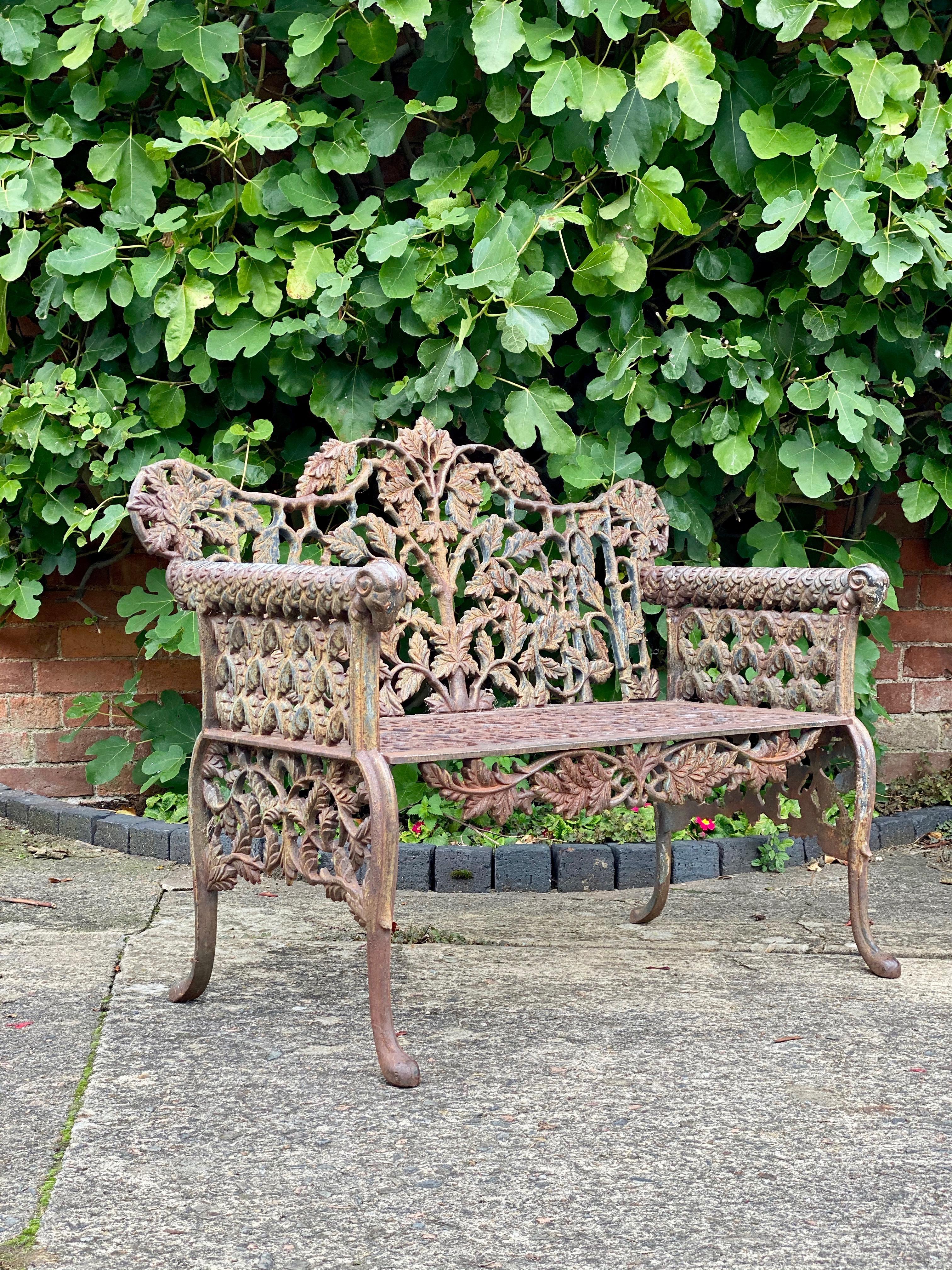 Beautiful Victorian style cast iron garden bench seat

Beautiful heavy Victorian style cast iron garden bench, arms terminating with rams heads with oak leaf pattern to back with Gothic style lattice work to sides, front apron with scrolling