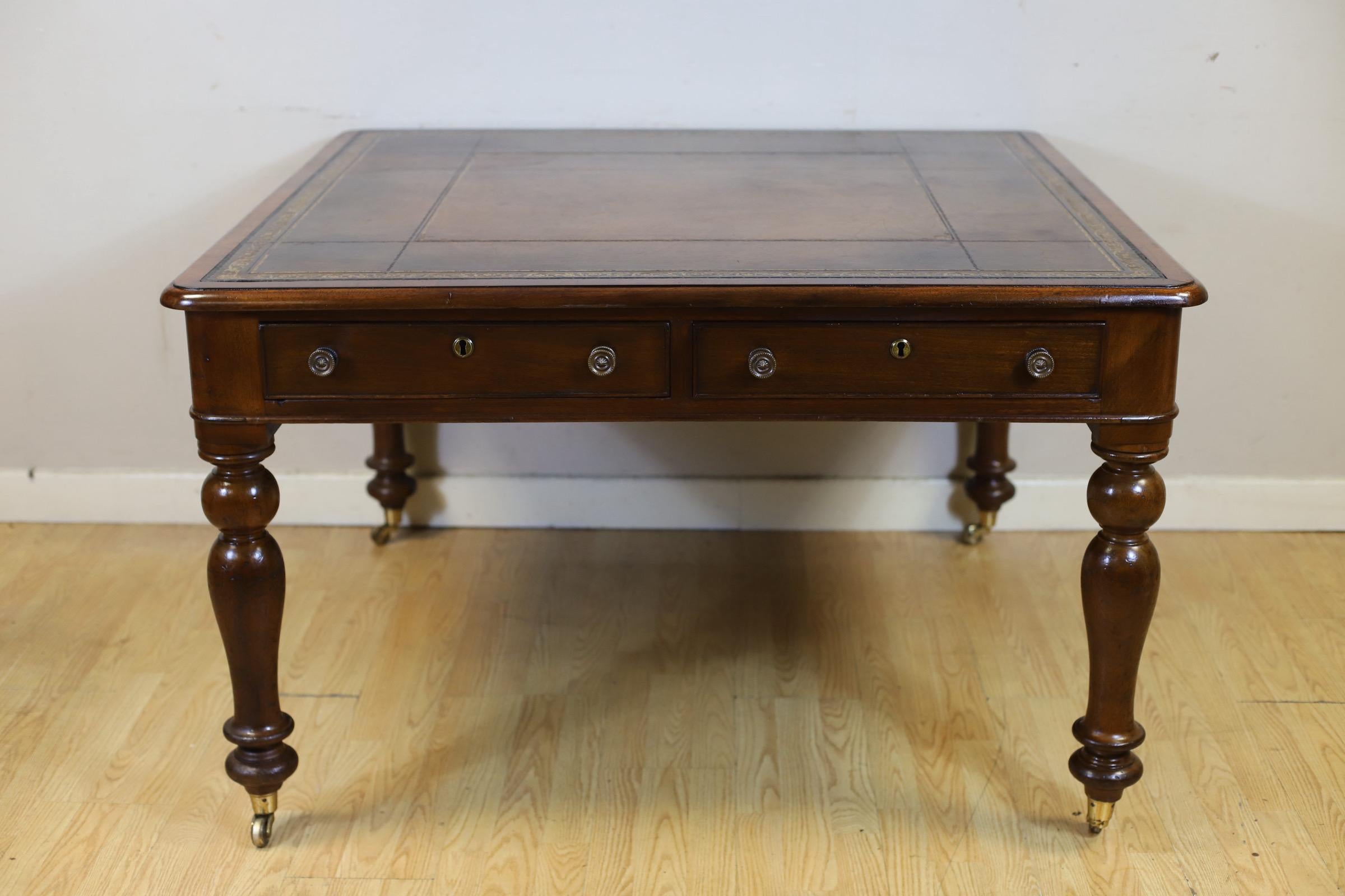 Nos complace poner a la venta esta impresionante mesa cuadrada de caoba victoriana para escritorio de biblioteca. Encimera de cuero repujado marrón, borde moldurado, un par de cajones de friso a cada lado, soportes ahusados torneados que terminan en