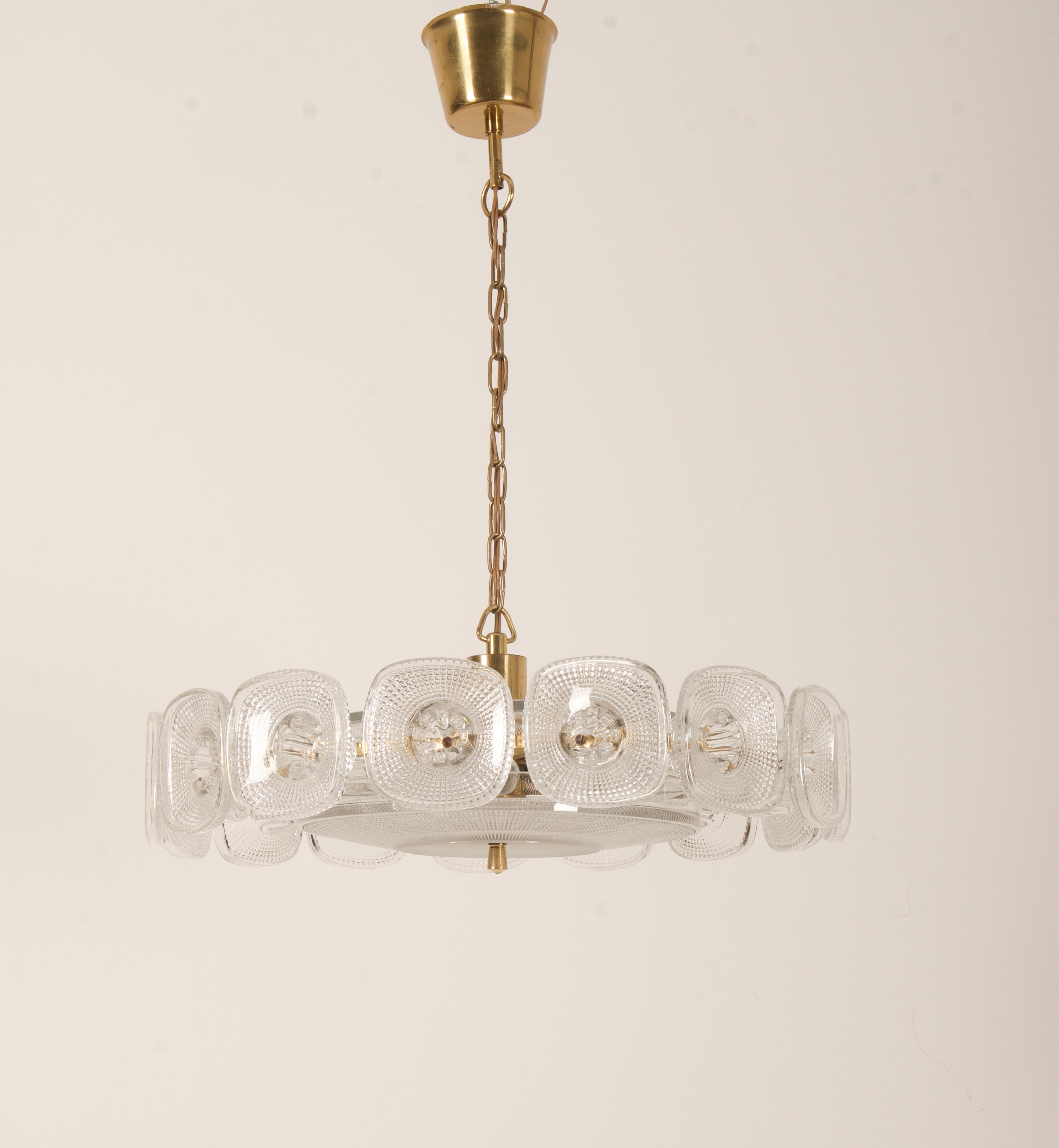Messingkonstruktion vergoldet, mit fünf E14-Fassungen. Das Ornamentdekor aus Pressglas, entworfen von Kjell Blomberg für Gullaskrufs glasbruk in Schweden in den 1960er Jahren.