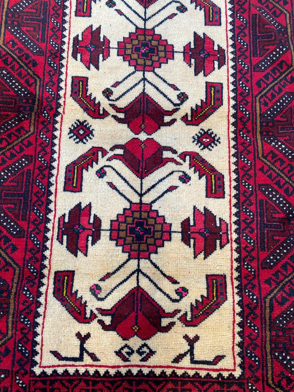 Exquisite 20th-century Afghan rug featuring a captivating geometrical design and stunning colors, including beige, red, green, purple, and black. Meticulously hand-knotted with wool velvet on a cotton foundation. A timeless piece of art for your