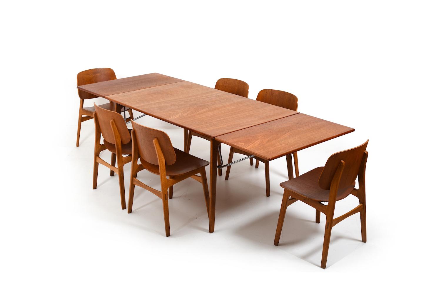 Beautiful vintage Børge Mogensen dining set consisting of a table mod. 162 and dining chairs mod. 155. Made in selected teak and oak. With metal struts below the table top. These also serve to expand the table (to hold the plates). Produced Søborg