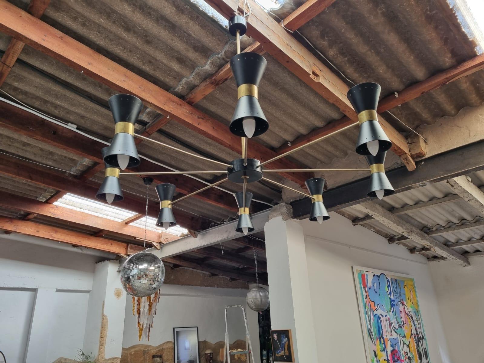 Italian Stilnovo lamp from the 1950s in the style of Sarfatti Stilnovo, it is made of 8 arms and lampshades, 16 bulb sockets with new electrical cables and a beautiful patinated brass, very good vintage condition, partially restored with some signs