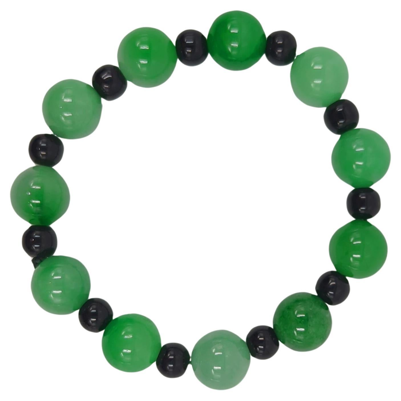 This beautiful vintage Chinese bracelet is a testament to the timeless elegance and allure of natural jadeite jade. Comprising beads of very high-grade emerald green tones, the bracelet exudes a wet, translucent clarity that makes each bead uniquely
