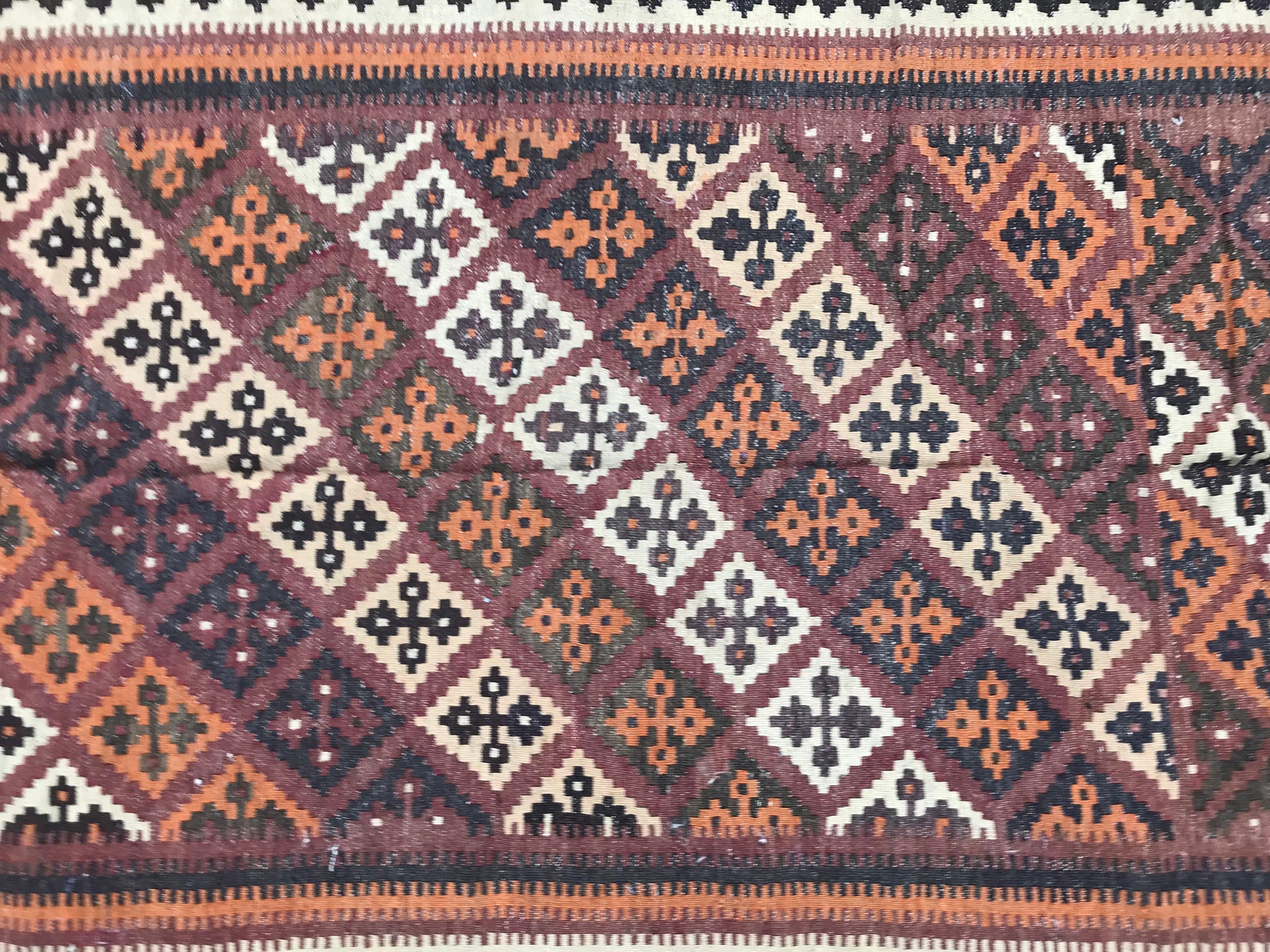 Nice mid-20th century Kilim with a geometrical tribal design and beautiful colors with orange, purple, black and green, entirely handwoven with wool on wool foundation. Size: 4ft 3.58inch x 8ft 0.86inch.