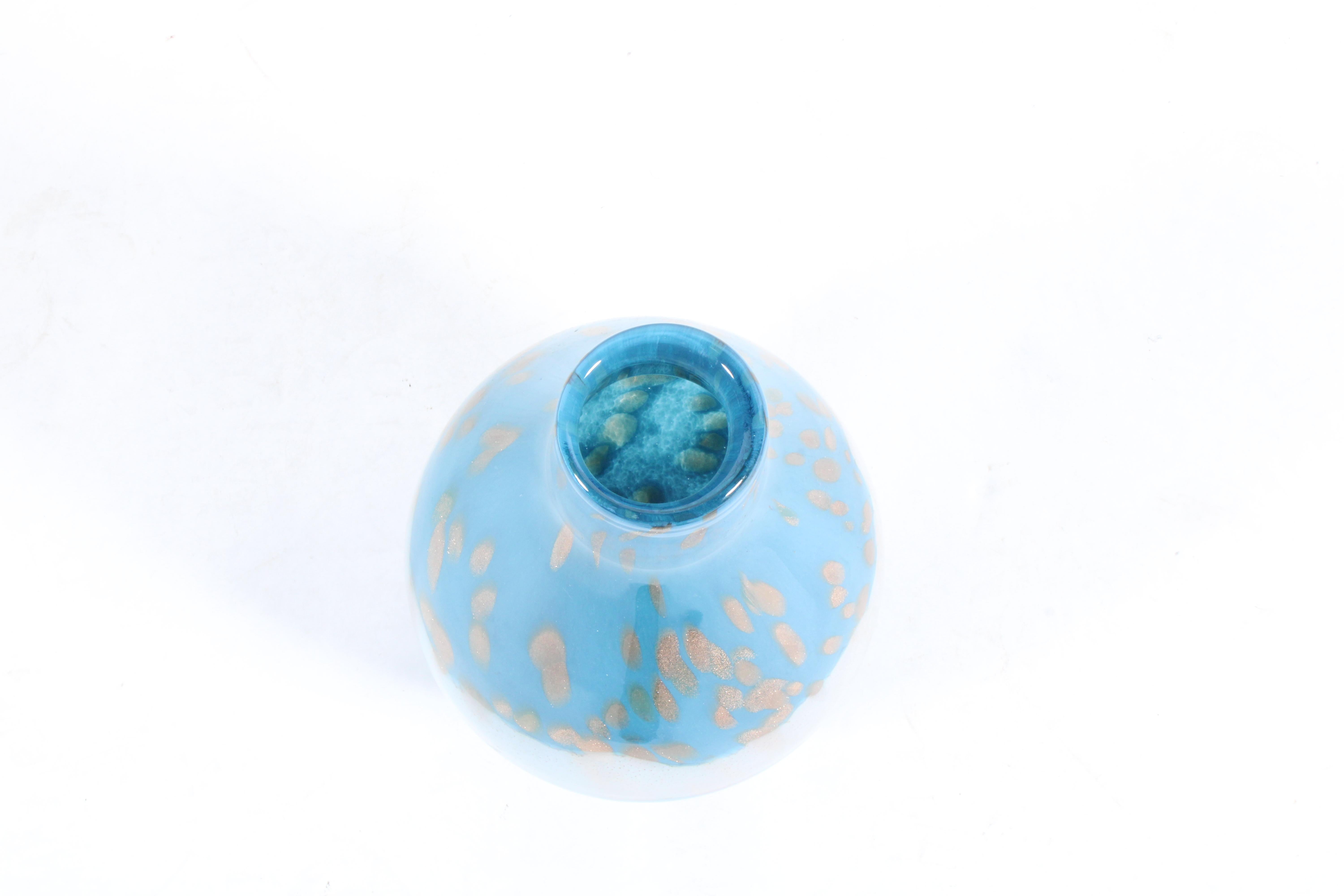 Vintage By By est un vase en verre bleu, blanc et or de forme bulbeuse.  Un magnifique objet de décoration pour la table ou le buffet, en superbe état vintage.

Italien vers 1960