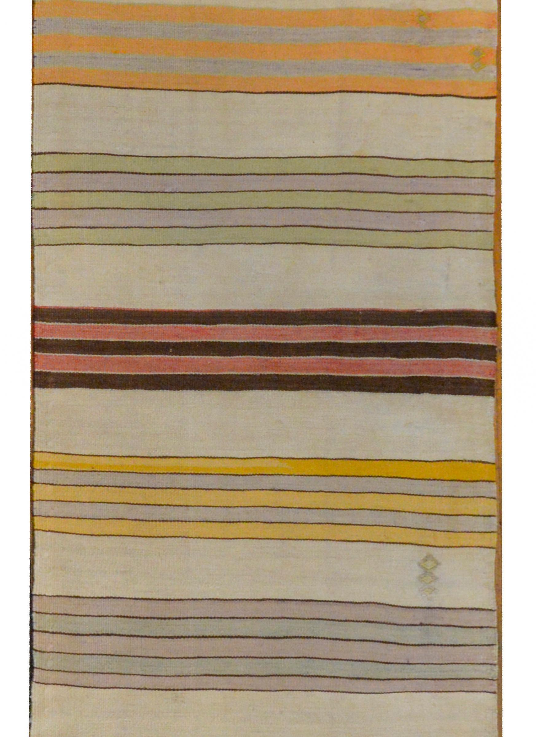A beautiful vintage mid-20th century Turkish Konya kilim runner with a striped pattern of pastel colored stripes with a geometric design on each end.