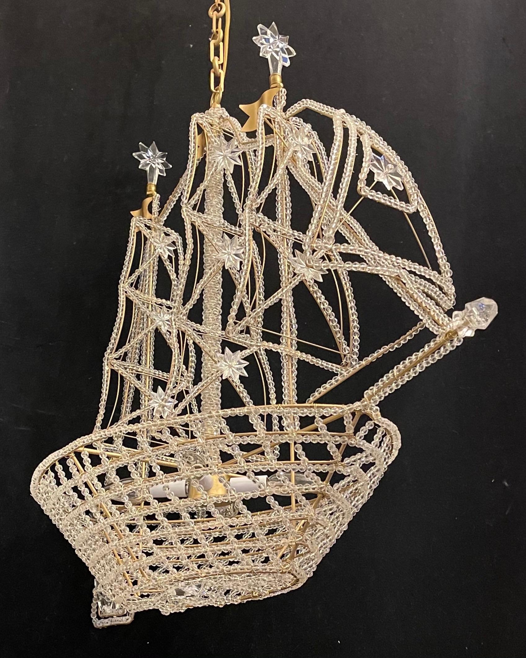A wonderful boat / ship chandelier that is beautifully detailed with a beaded crystal hull and sails crystal star accents throughout and finished with a rock crystal finial at the bow. Outfitted with 4 internal lights, In the manner of Baguès.
This