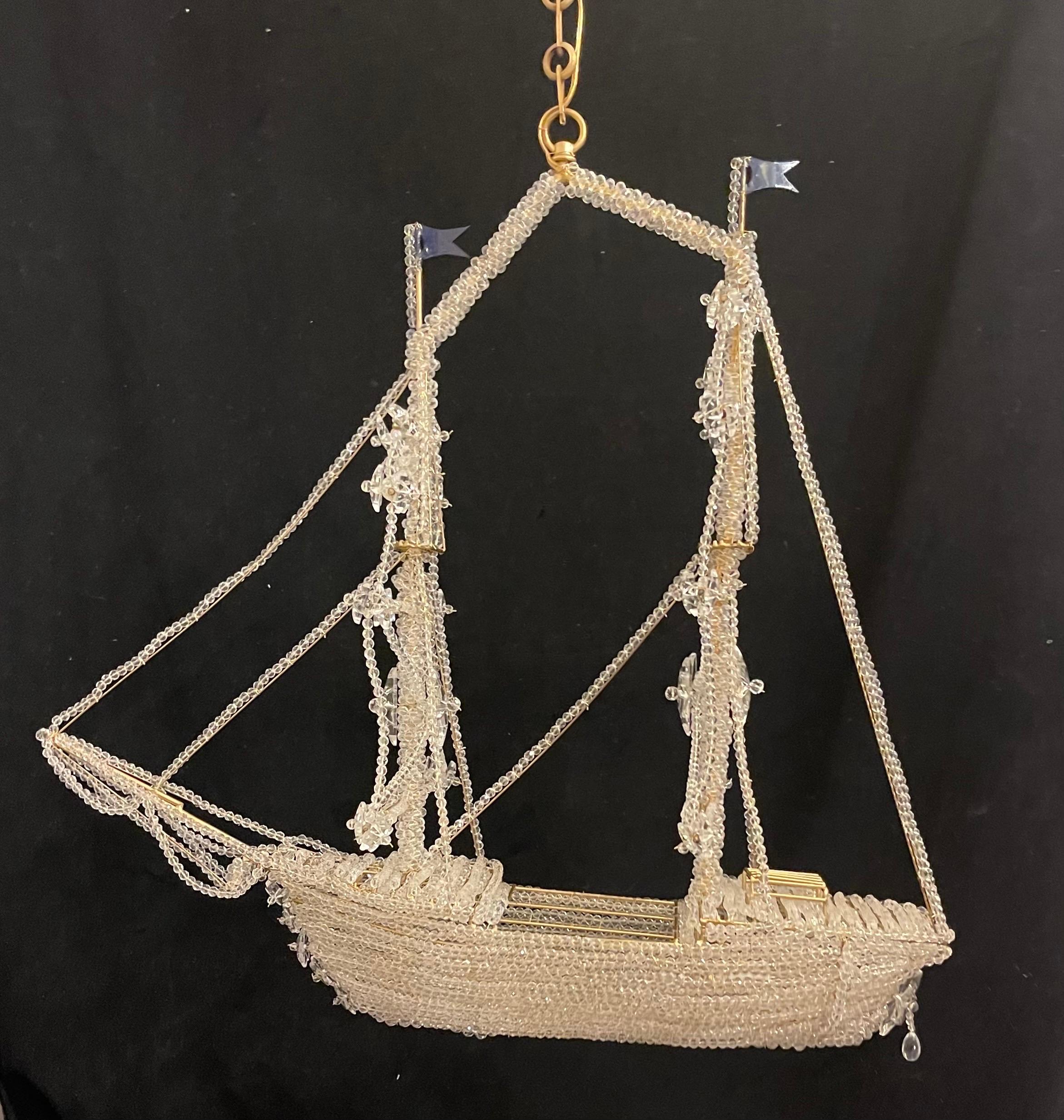 A wonderful boat / ship chandelier that is beautifully detailed with a beaded crystal hull and sails crystal star accents throughout. Outfitted with 3 internal lights, In the manner of Baguès.
This would be a beautiful addition to any space!
This
