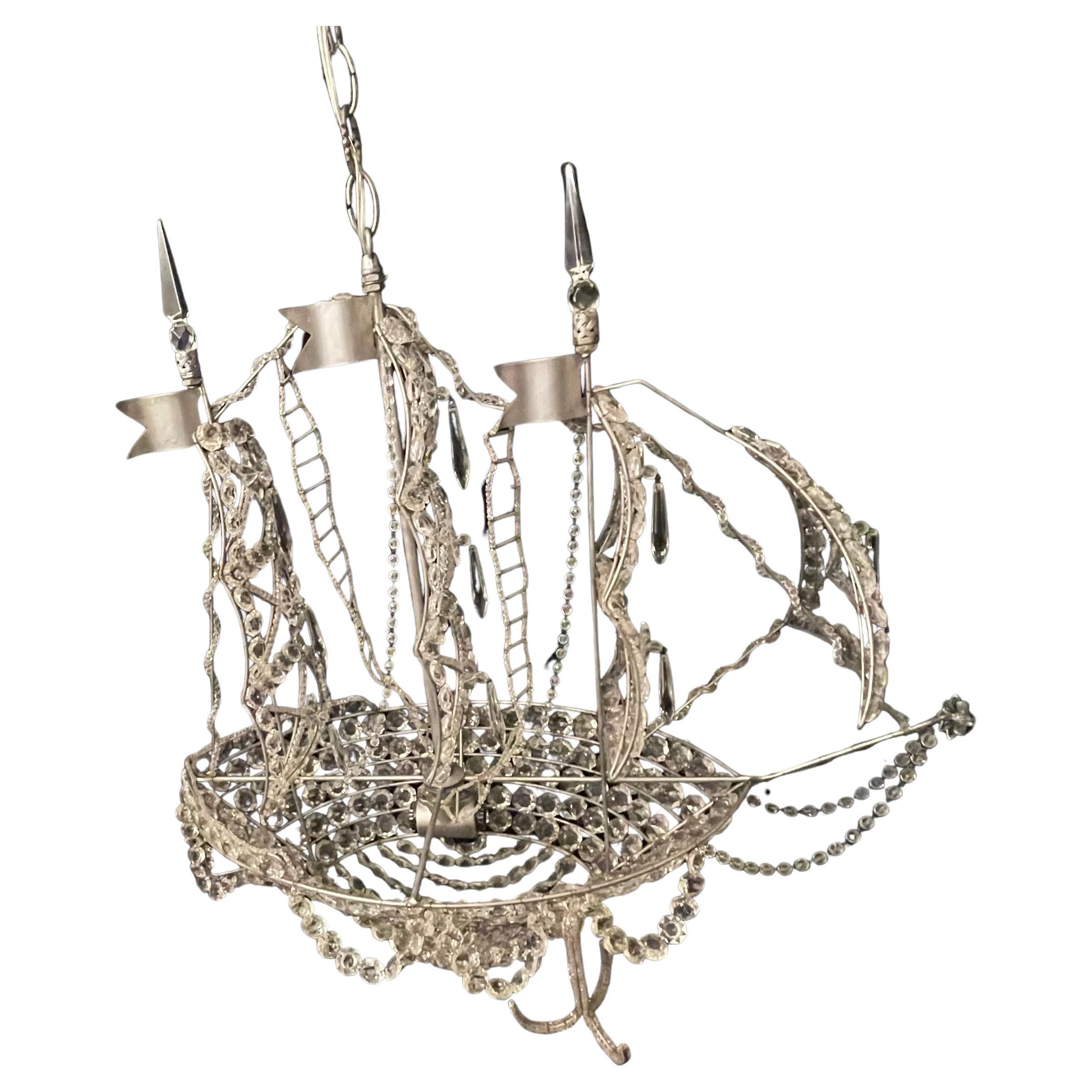 A wonderful silver gilt boat / ship chandelier that is beautifully detailed with a crystal crystal hull and beaded sails crystal star accents throughout. Outfitted with 2 candelabra internal lights, In the manner of Baguès.
This would be a beautiful