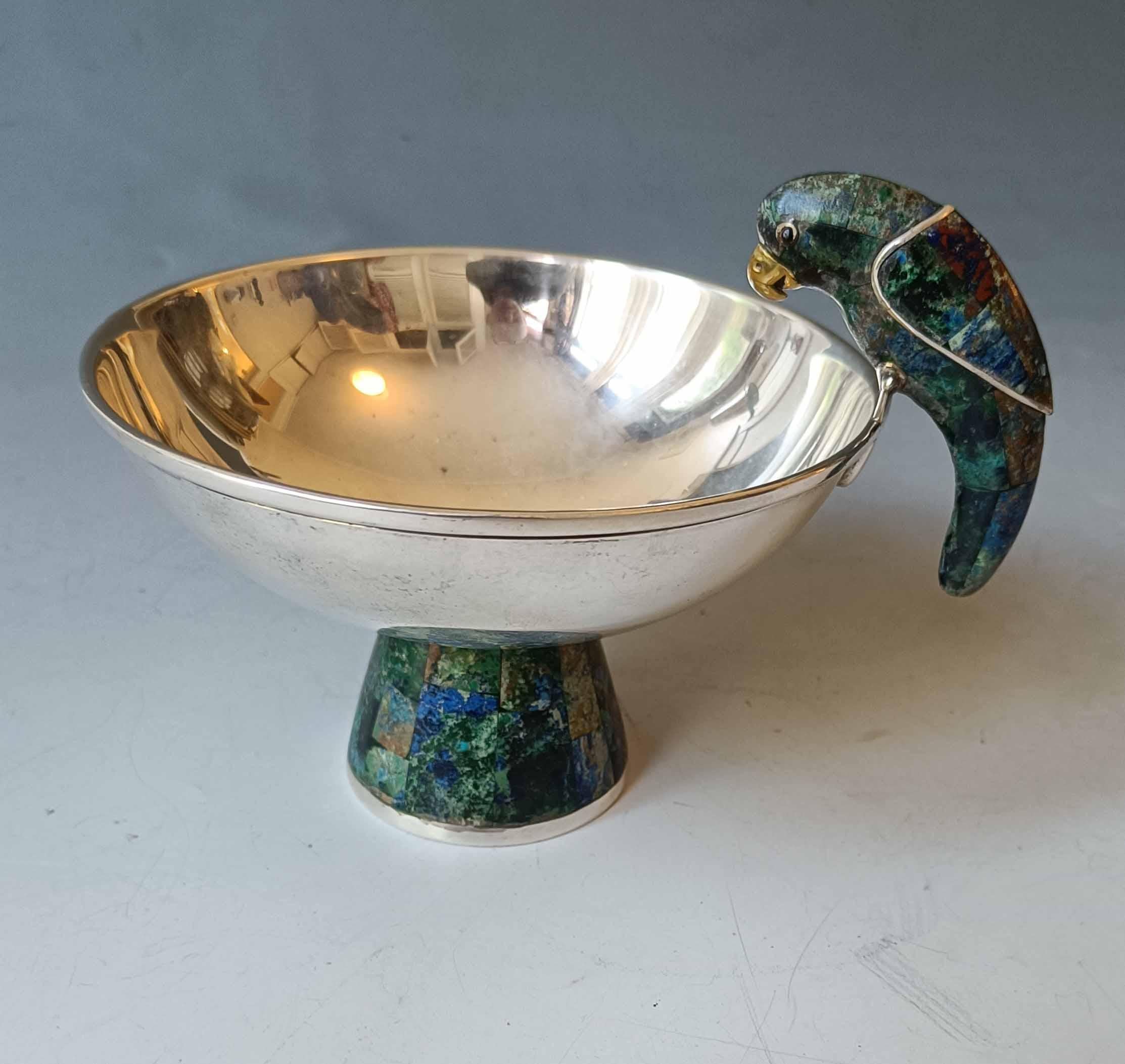 Fine Vintage Los Castillo bowl with stone inlayed parrot  
A Vintage Taxco pedestal bowl hand crafted in silver plated 
copper featuring a stylized Parrot and pedestal section  in mosaic green stone 
Signed Los Castillo Mexico on the underside
