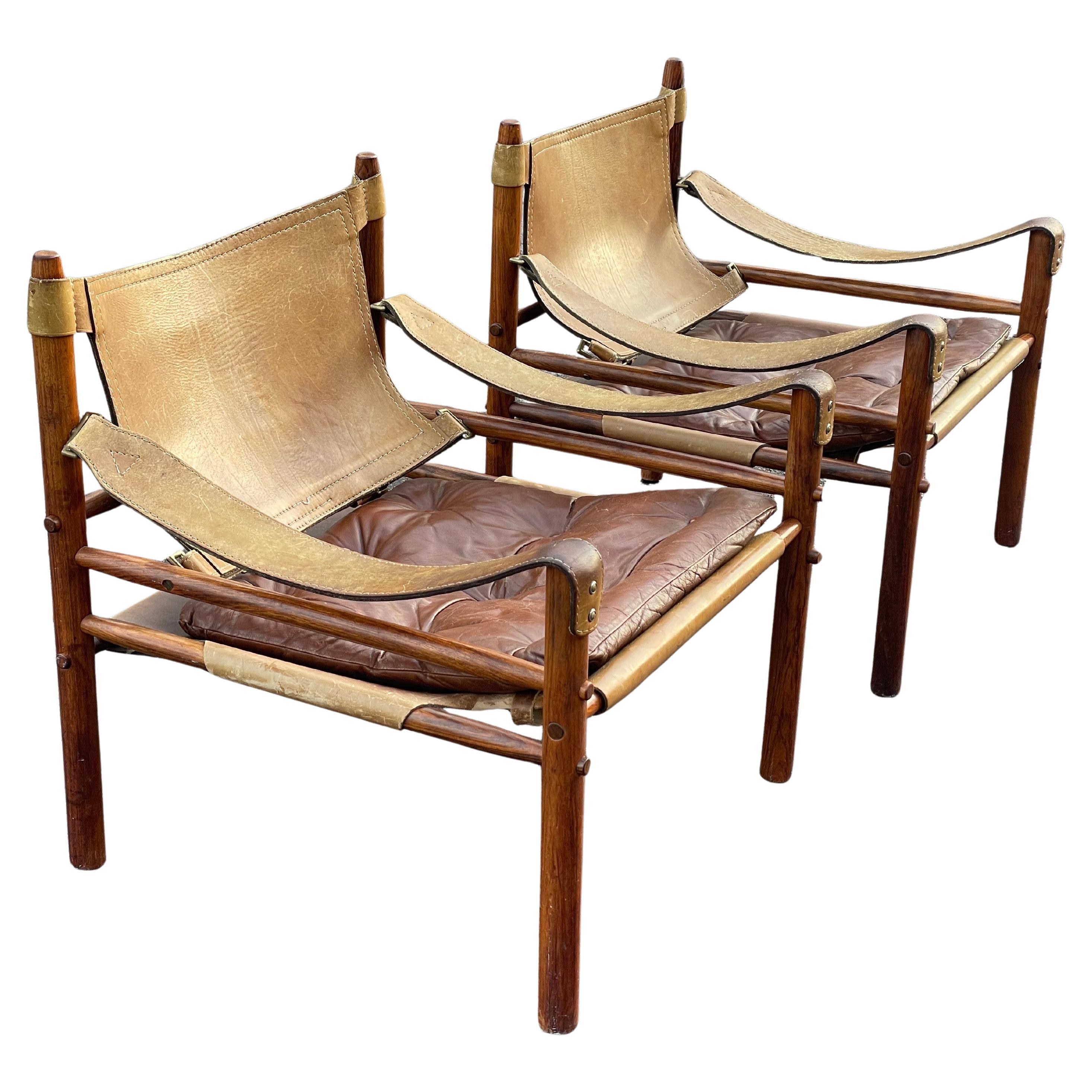 Pareja de icónicas sillas safari Sirocco de Arne Norell, fabricadas en la década de 1970 por Arne Norell AB en Aneby, Suecia. Con cuero original y armazón de madera maciza, estas sillas están en buen estado y muestran un diseño escandinavo atemporal