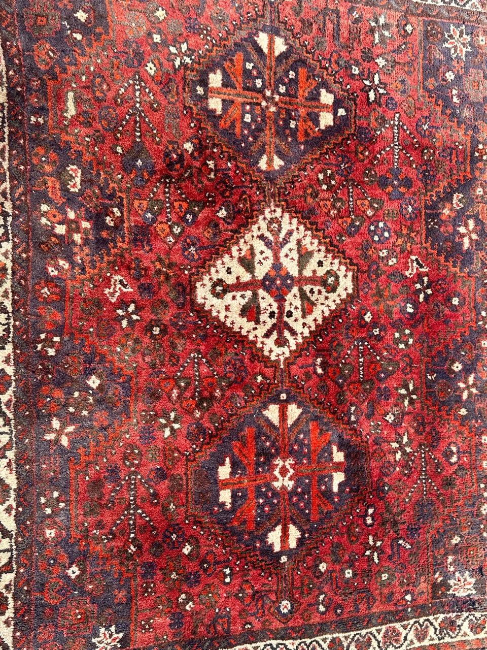 Nice mid century Shiraz rug with beautiful tribal and geometrical design with stylized flowers and animal designs, and nice colours with a red background, blue, green, orange, brown, black and white, entirely hand knotted with wool on wool