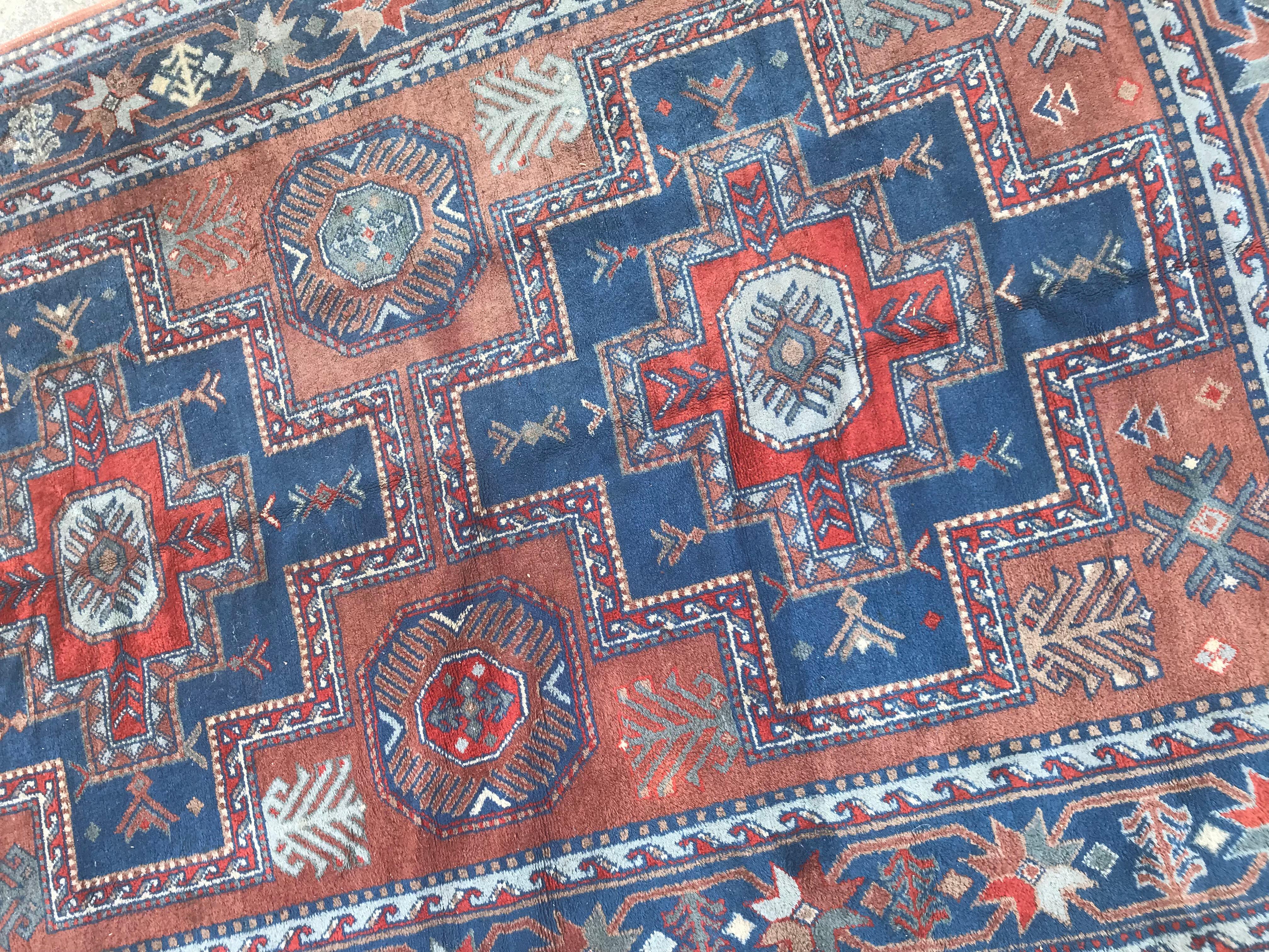 Nice Sinkiang rug with Caucasian geometrical design and beautiful colors with orange, green and blue, entirely hand knotted with wool velvet on cotton foundation. Measures: 5ft 7in x 8ft 10in.