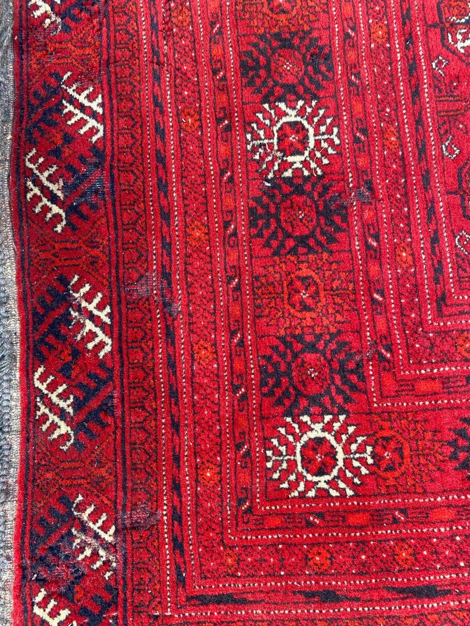 Nice vintage Afghan rug with a beautiful geometrical Bokhara design and red field color, entirely and finely hand knotted with wool velvet on wool foundation.